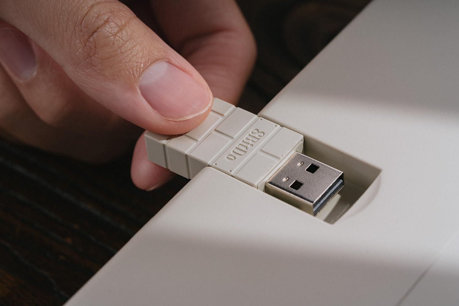 Zbliżenie złącza USB wkładanego do urządzenia. Złącze jest jasnego koloru.