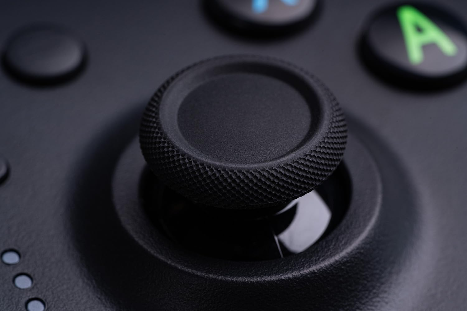 Zbliżenie czarnego joysticka z teksturowaną powierzchnią i czarnym tłem.