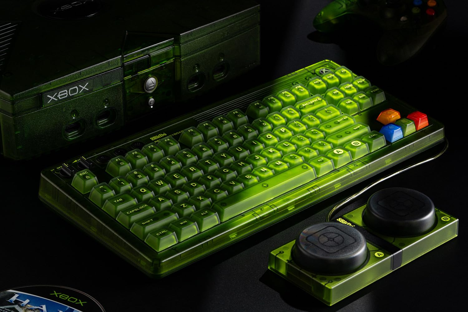 Una tastiera verde con una console Xbox e un controller abbinati. La tastiera e la console sono illuminate.