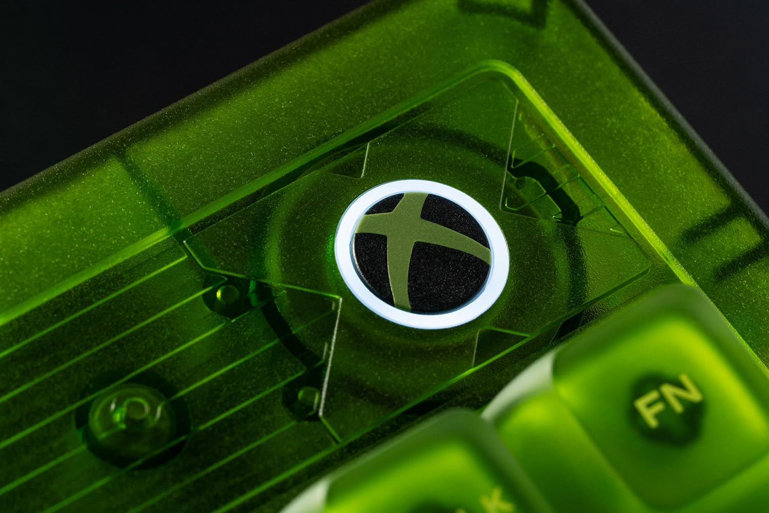 Primo piano del logo Xbox su una tastiera verde. È un pulsante circolare con un contorno bianco.
