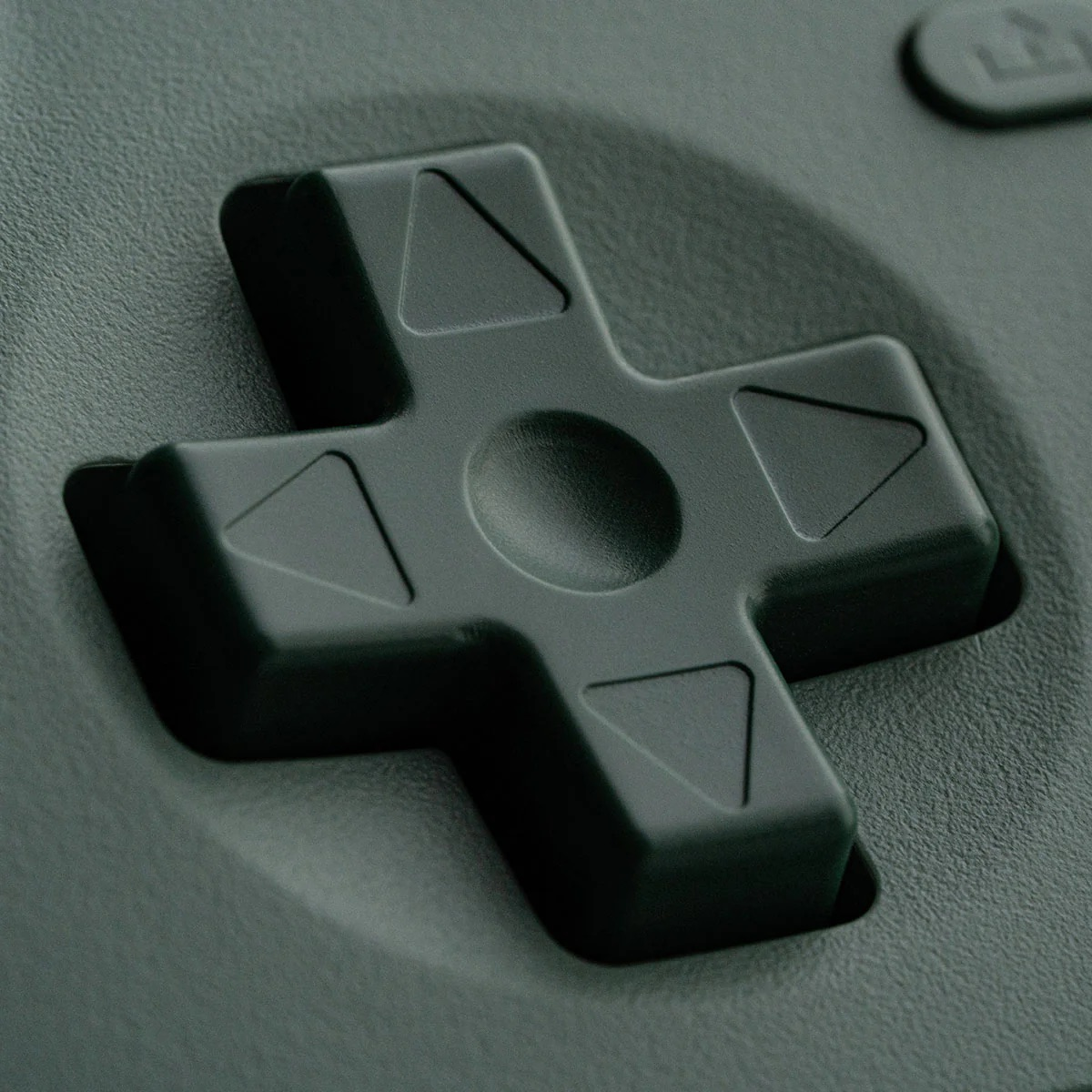 Un primo piano di un pad direzionale grigio a forma di croce su un controller.