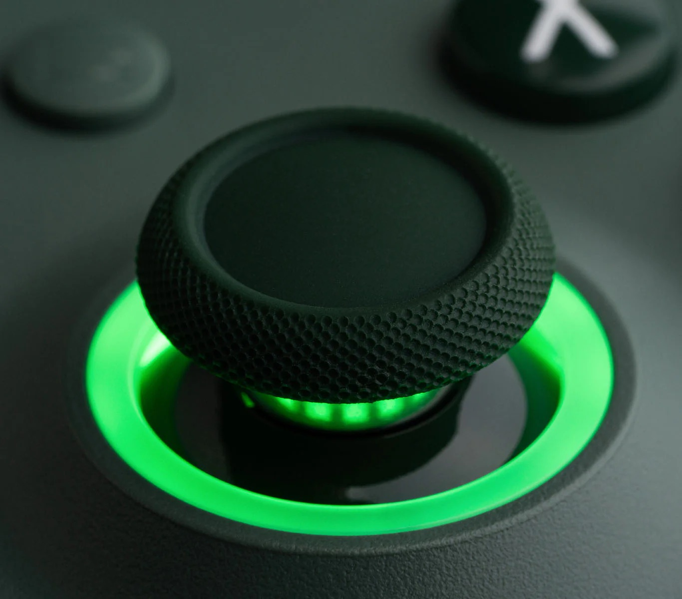 Primo piano di un joystick verde con impugnatura strutturata e base luminosa.