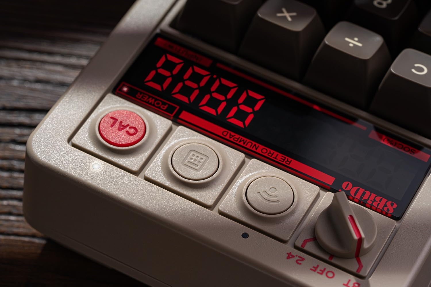 Zbliżenie retro klawiatury numerycznej z wyświetlaczem 8888. Przyciski beżowe i czerwone.