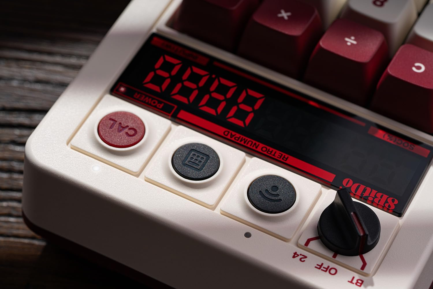 Zbliżenie klawiatury kalkulatora z przyciskami. Wyświetlacz pokazuje liczby. Klawiatura jest biała i bordowa.