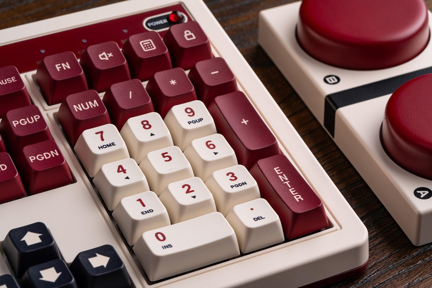 Zbliżenie białej i czerwonej klawiatury z klawiszami funkcyjnymi i klawiaturą numeryczną z dwoma czerwonymi okrągłymi przyciskami.