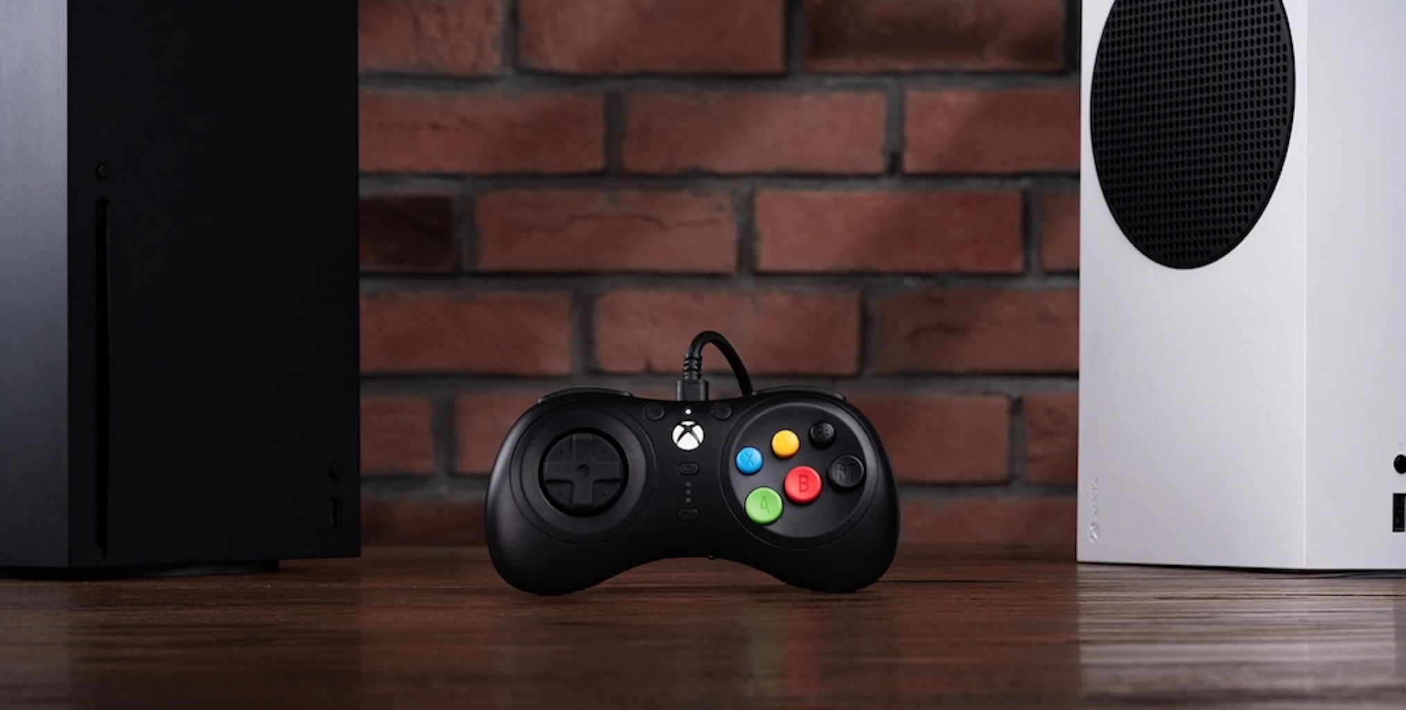 Un controller di gioco nero su una superficie di legno, con una Xbox Series S e X su entrambi i lati.