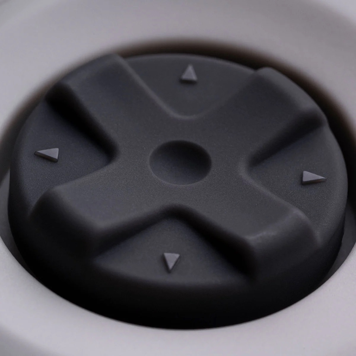 Zbliżenie szarego przycisku pada kierunkowego ze strzałkami. Ostrość na przycisku.