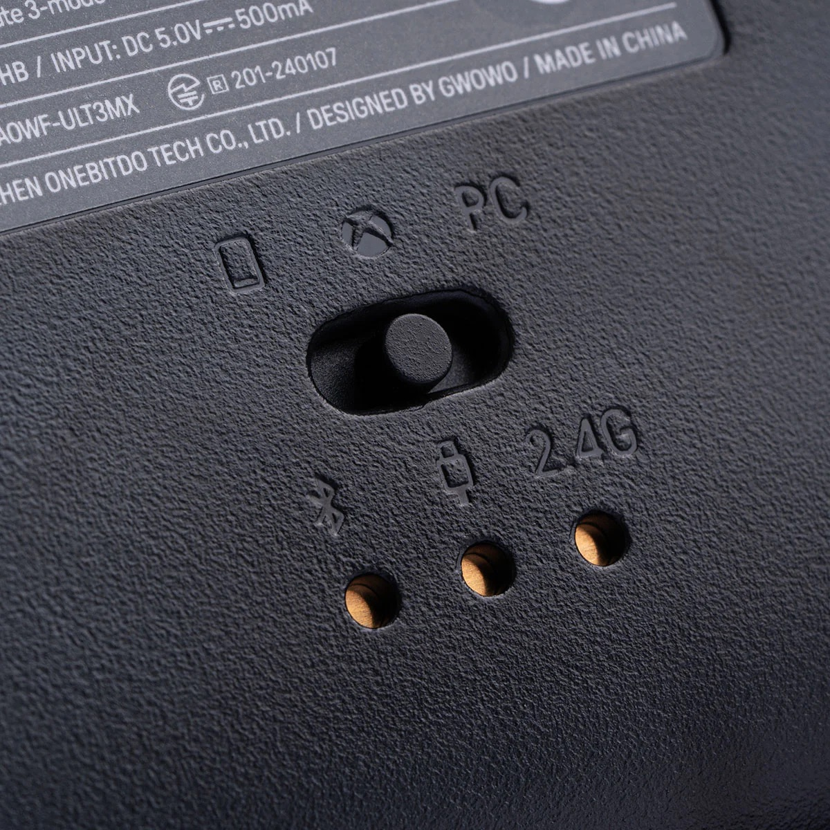 Primo piano di un controller di gioco nero che mostra l'interruttore di modalità e le opzioni di connessione.