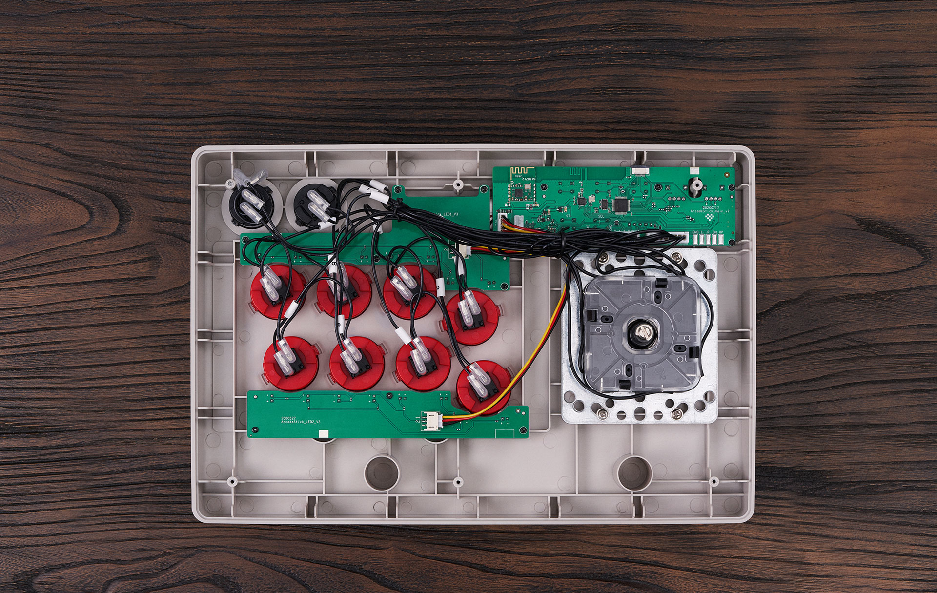 L'interno di un arcade stick, che mostra i componenti interni, inclusi i pulsanti rossi e un joystick.