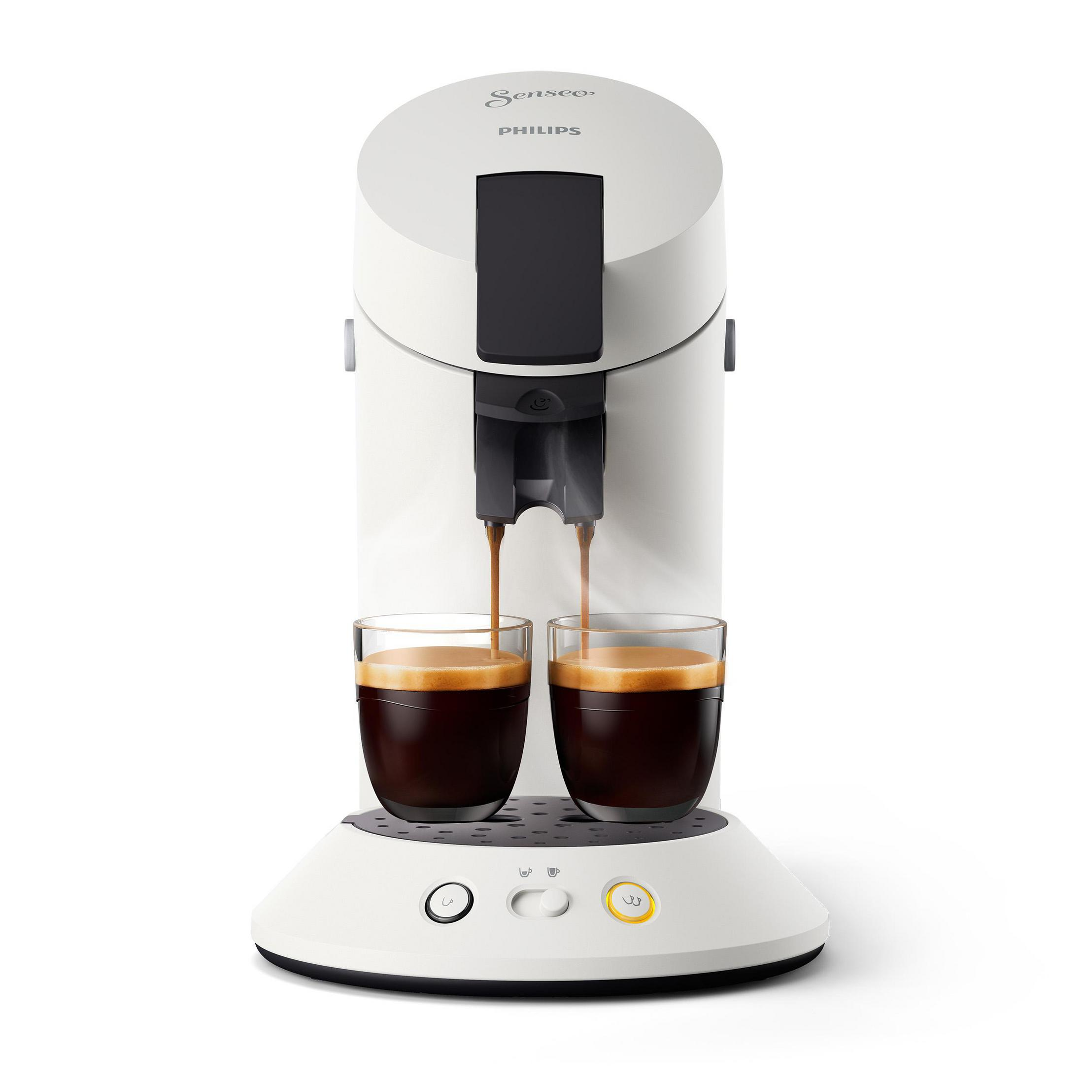 Weiße Kaffeemaschine mit Kaffee, der in zwei Gläser gegossen wird. Die Maschine hat einen schwarzen Deckel und einen weißen Sockel.