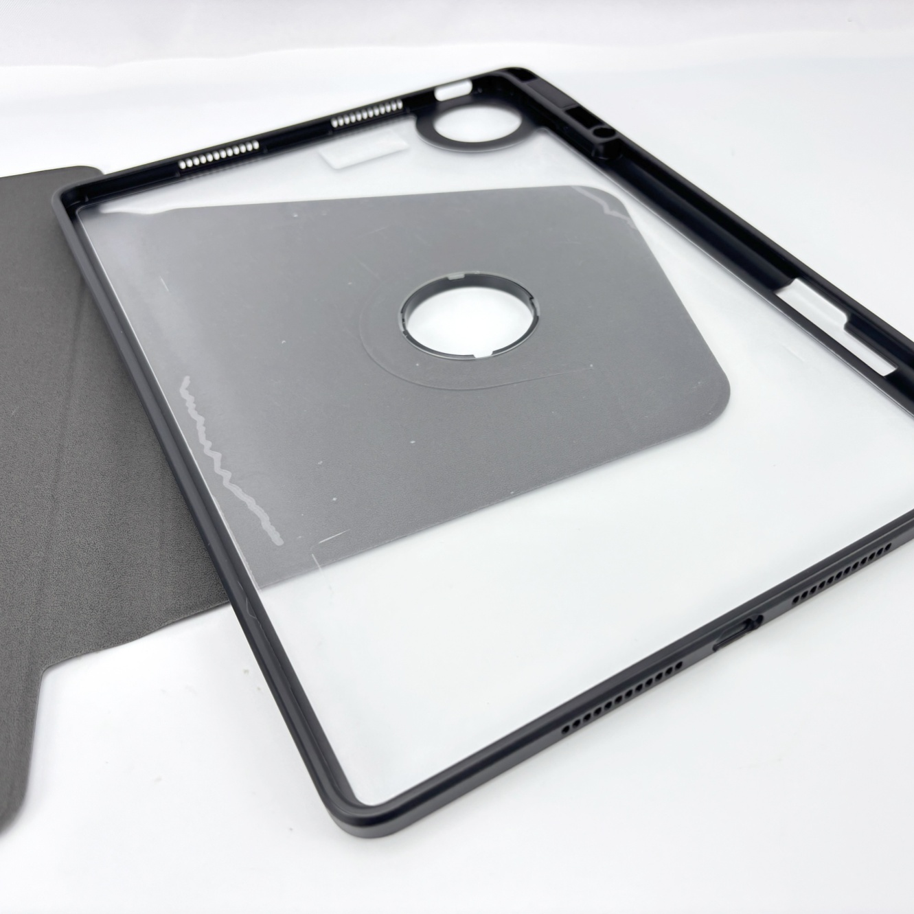 Nahaufnahme einer Tablet-Hülle mit schwarzem Rahmen und transparentem Deckel. Die Hülle ist offen.