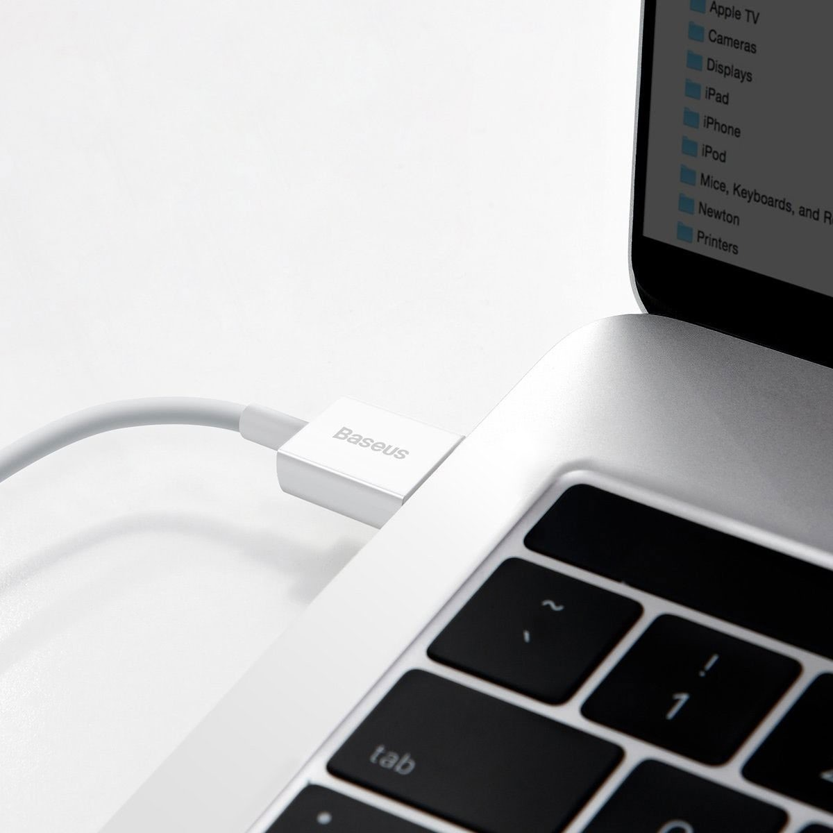 Een witte Baseus-kabel is aangesloten op een laptop. Het scherm toont een bestandsmap. Het toetsenbord staat centraal.