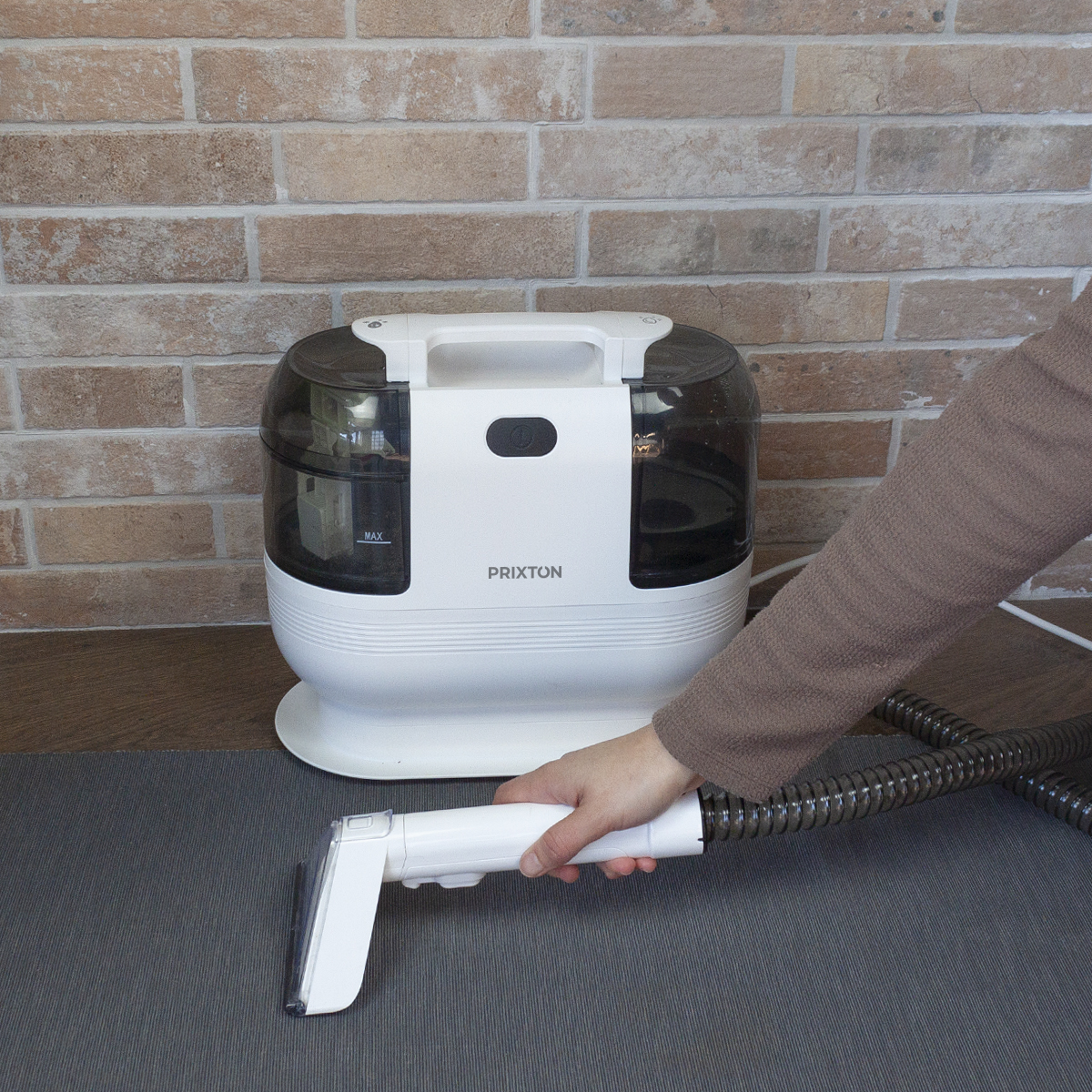 Ręka kobiety trzymająca odkurzacz i wąż.