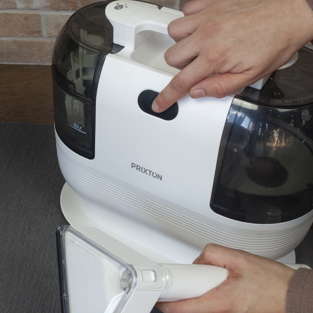 A close up of a woman's hands pressing a button on a vacuum.