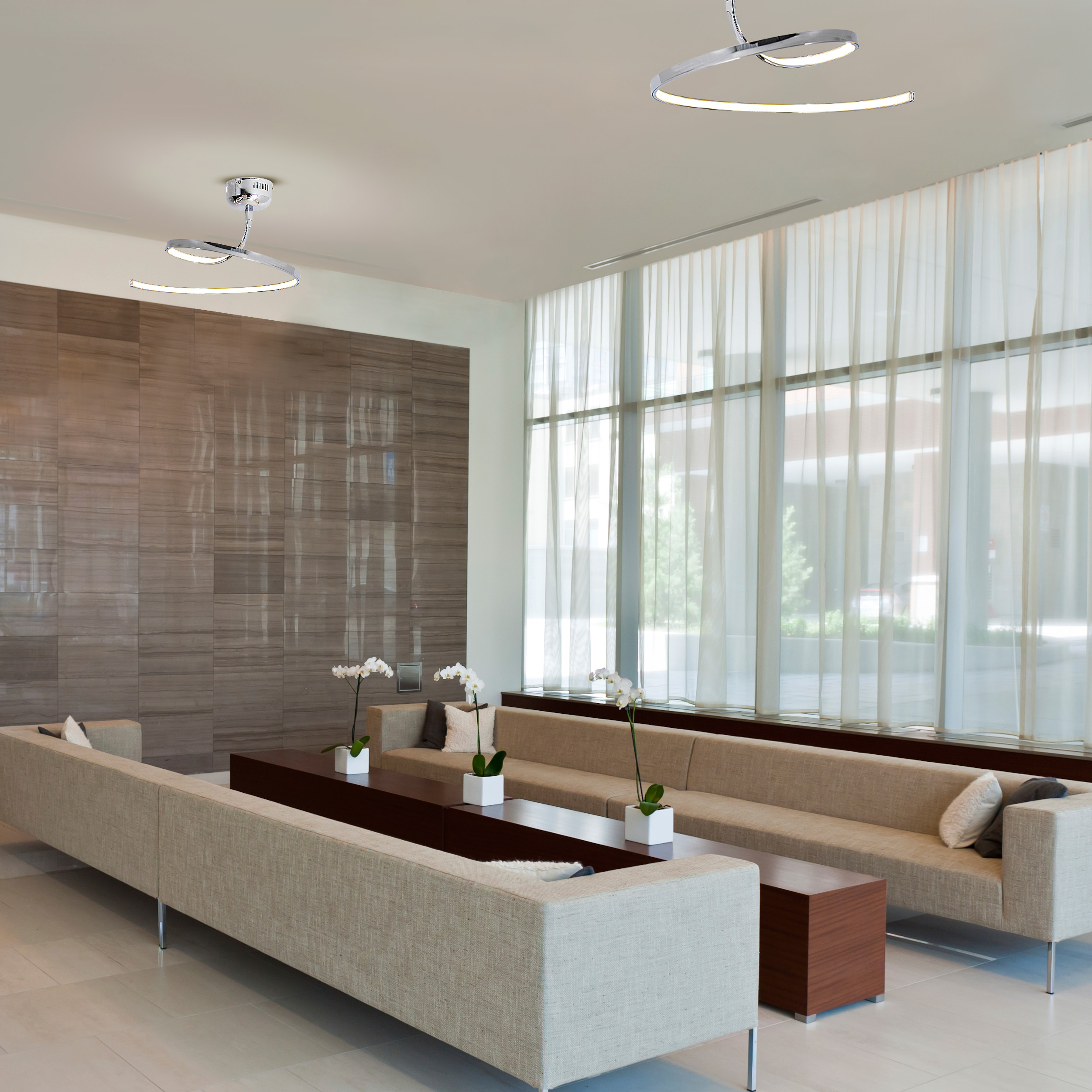 Moderne Lobby mit zwei kreisförmigen Deckenleuchten. Sofas, eine braune Wand und weiße Vorhänge.