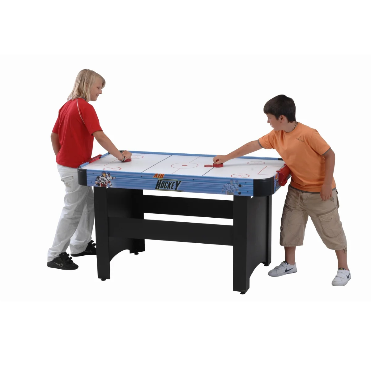 Two children playing air hockey. The table is blue, and they are using red paddles and a puck.