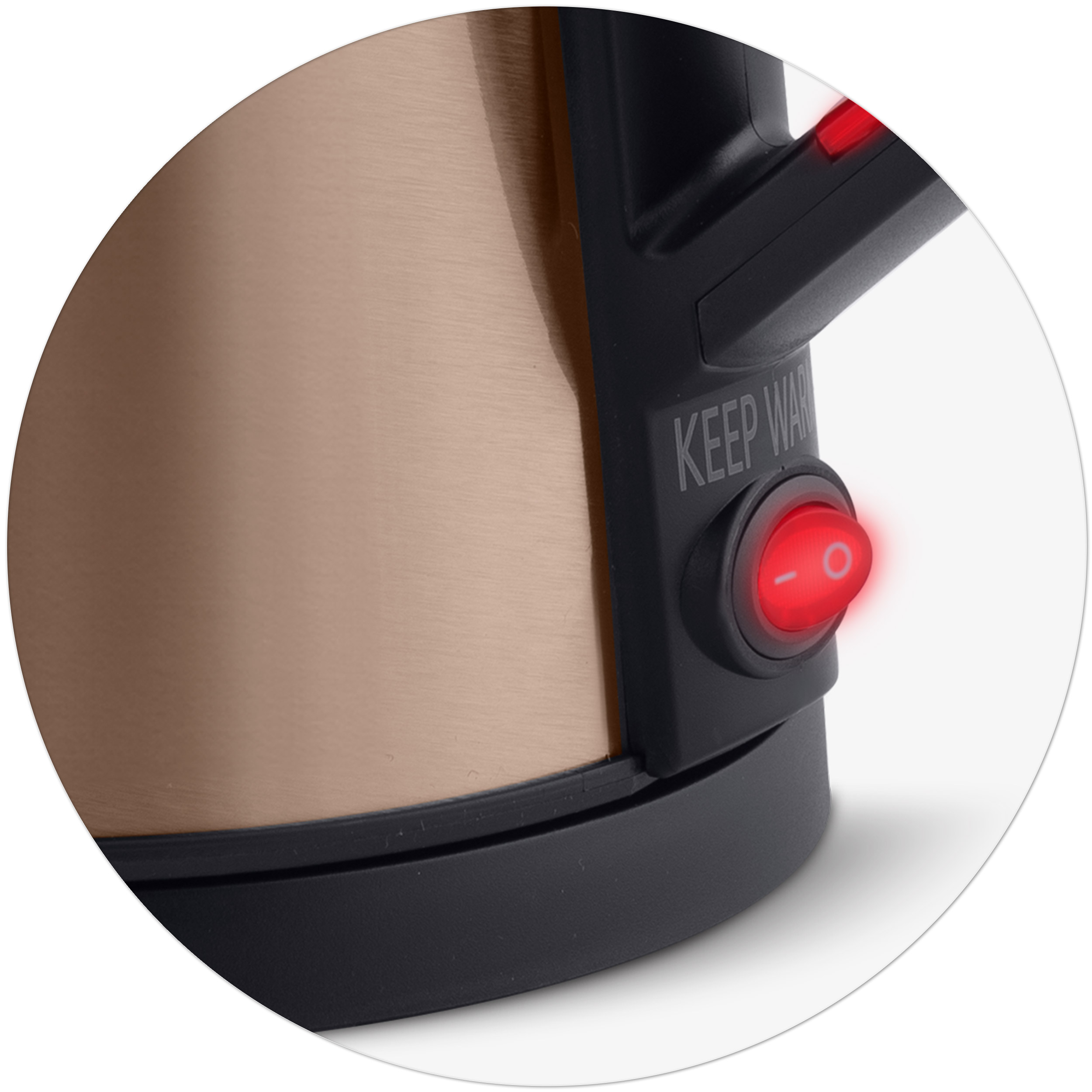 Zbliżenie czerwonego przycisku zasilania na czajniku w kolorze miedzi.