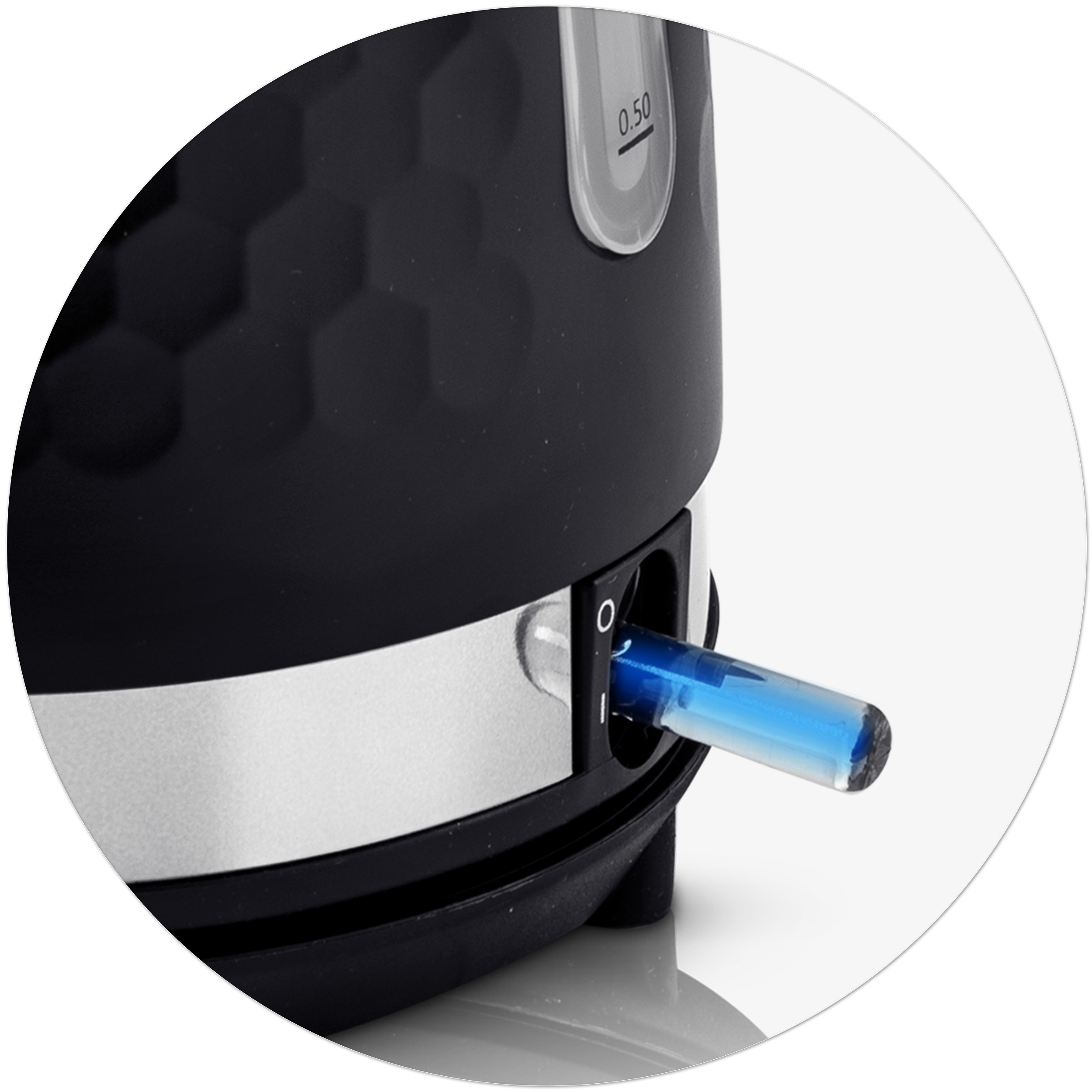 Zbliżenie czarnego włącznika czajnika z niebieskim światłem. Czajnik ma wzór plastra miodu i srebrną obwódkę.