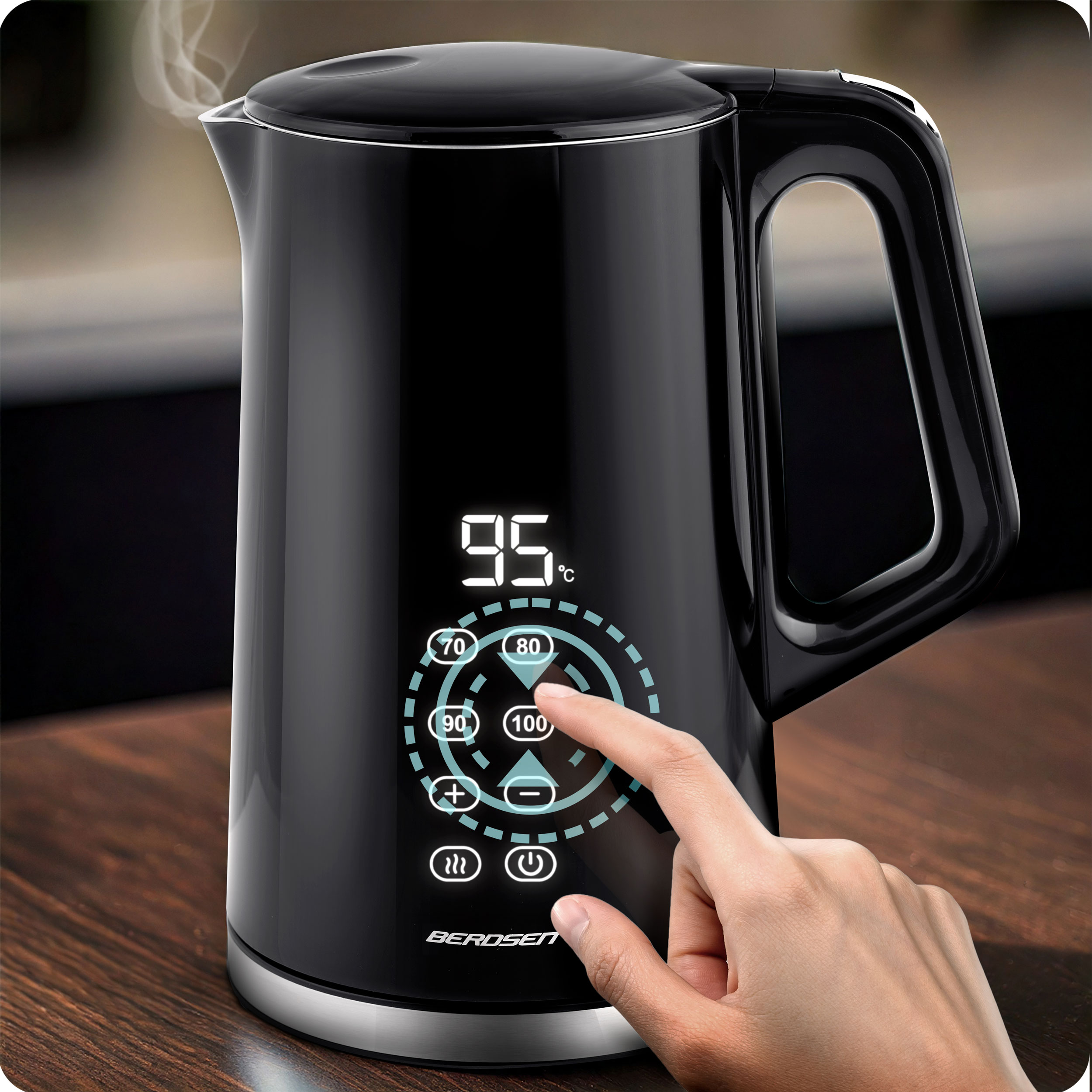Czarny czajnik z wyświetlaczem cyfrowym. Ręka dotyka ekranu dotykowego, aby wybrać 100 stopni Celsjusza.
