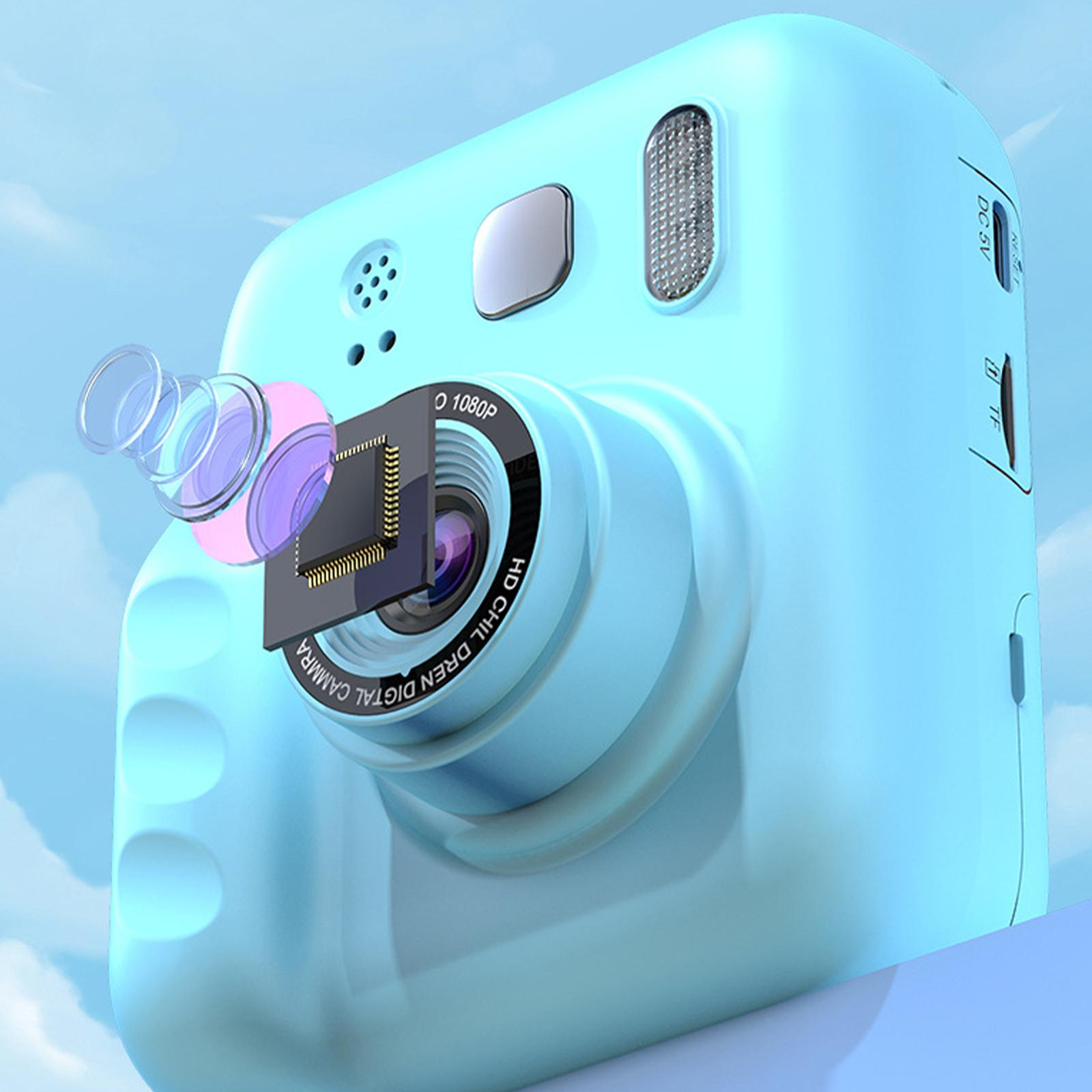Blaue Digitalkamera mit großem Objektiv und Bildschirm, vor bewölktem Himmel.