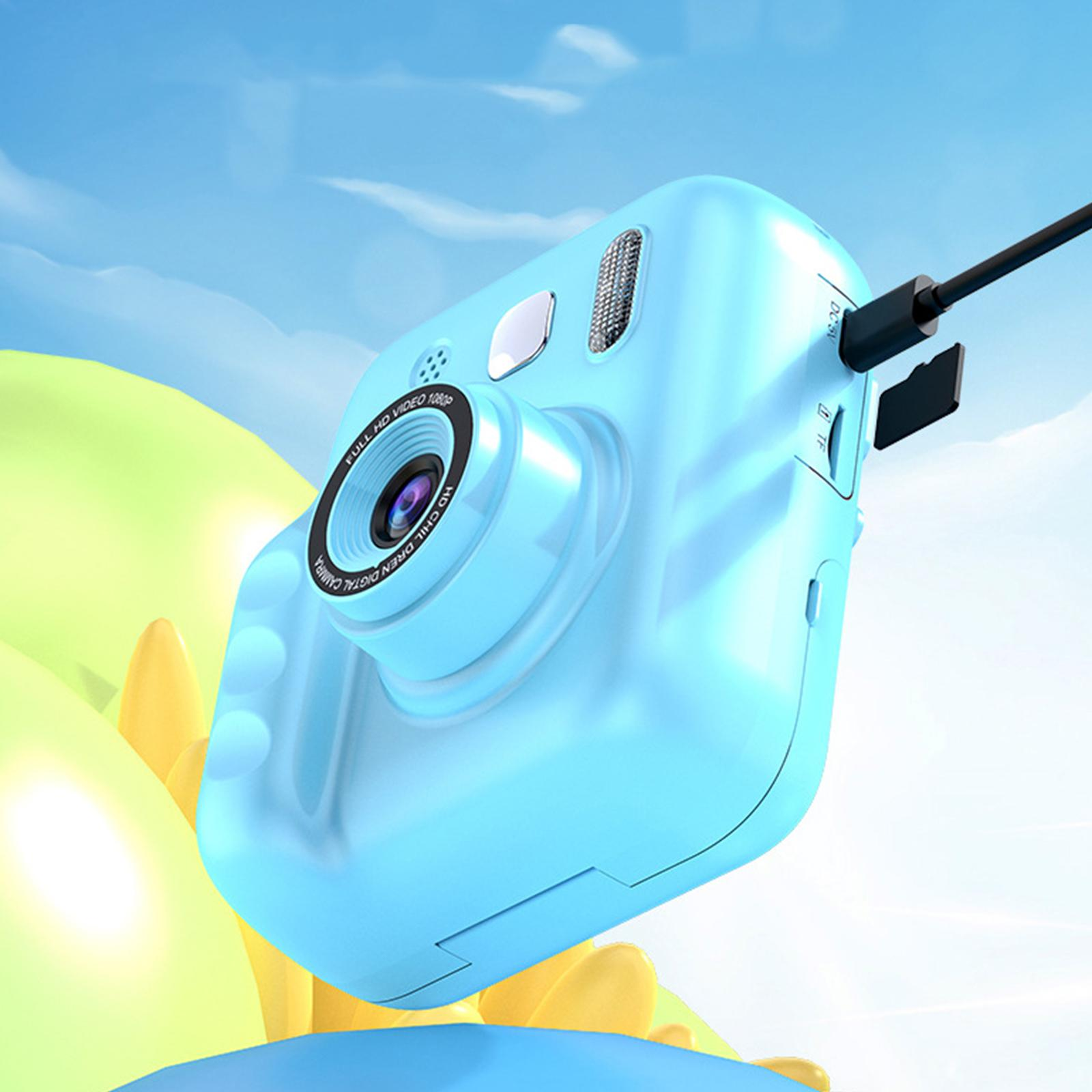Blaue Digitalkamera mit Objektiv, Knöpfen und Ladekabel. Der Hintergrund zeigt blauen Himmel und Wolken.