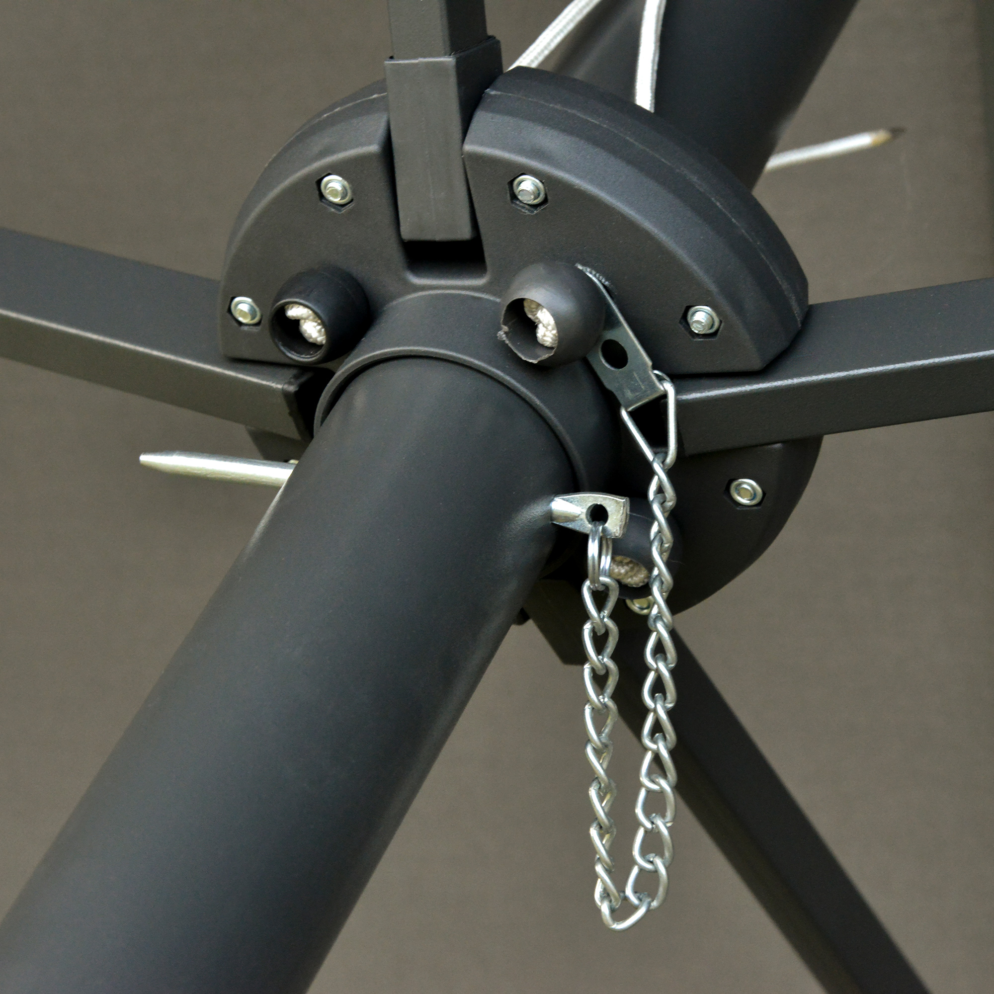 Nahaufnahme der schwarzen Metall-Schirmträgerstruktur mit Kette. Die Struktur ist verschraubt.