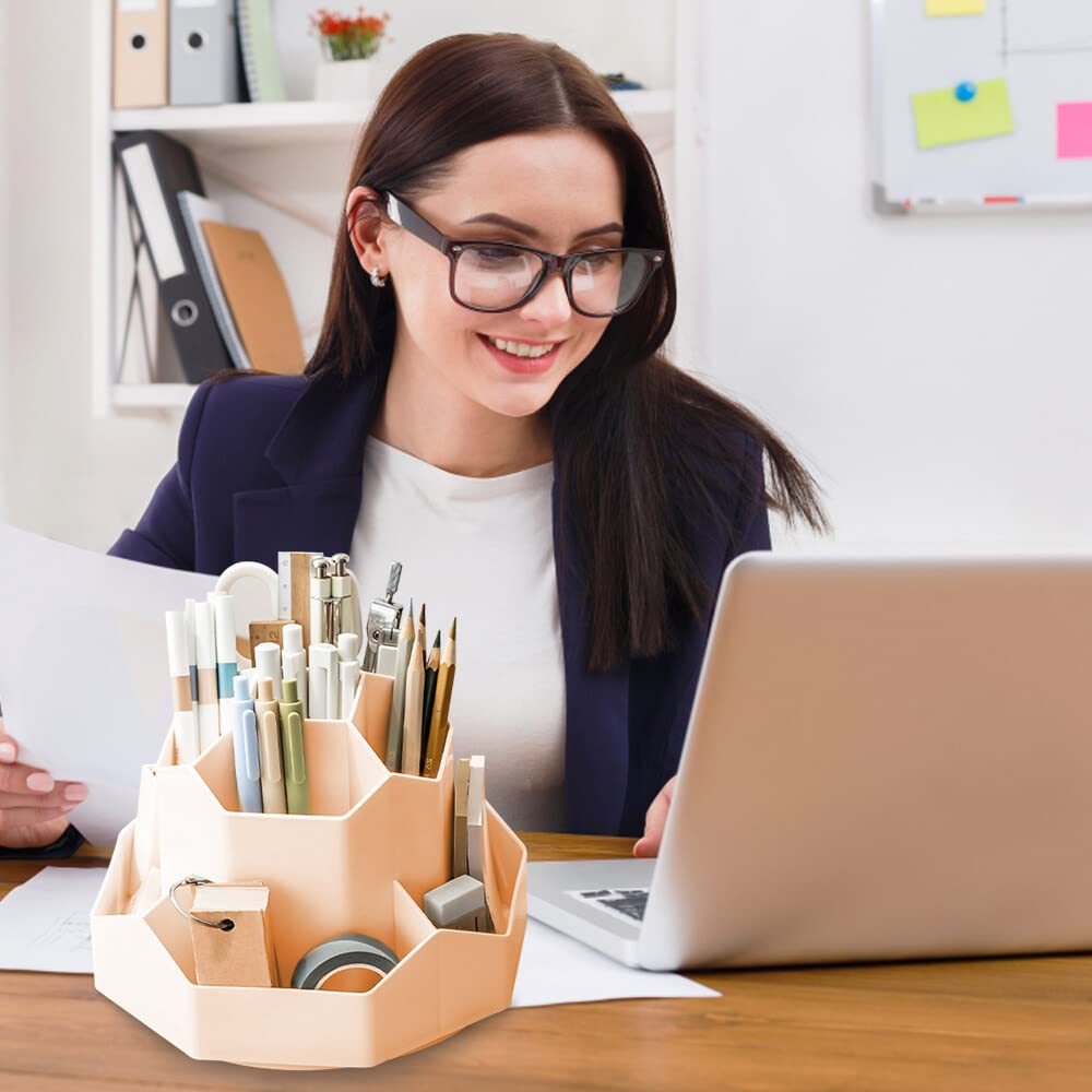 Eine Frau mit Brille arbeitet an einem Laptop, mit einem Schreibtisch-Organizer mit Stiften und Büromaterialien in der Nähe.