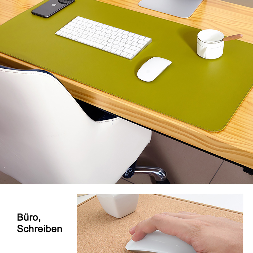 Eine grüne Schreibtischunterlage mit Tastatur, Maus und einem weißen Becher. Ein Holzschreibtisch.