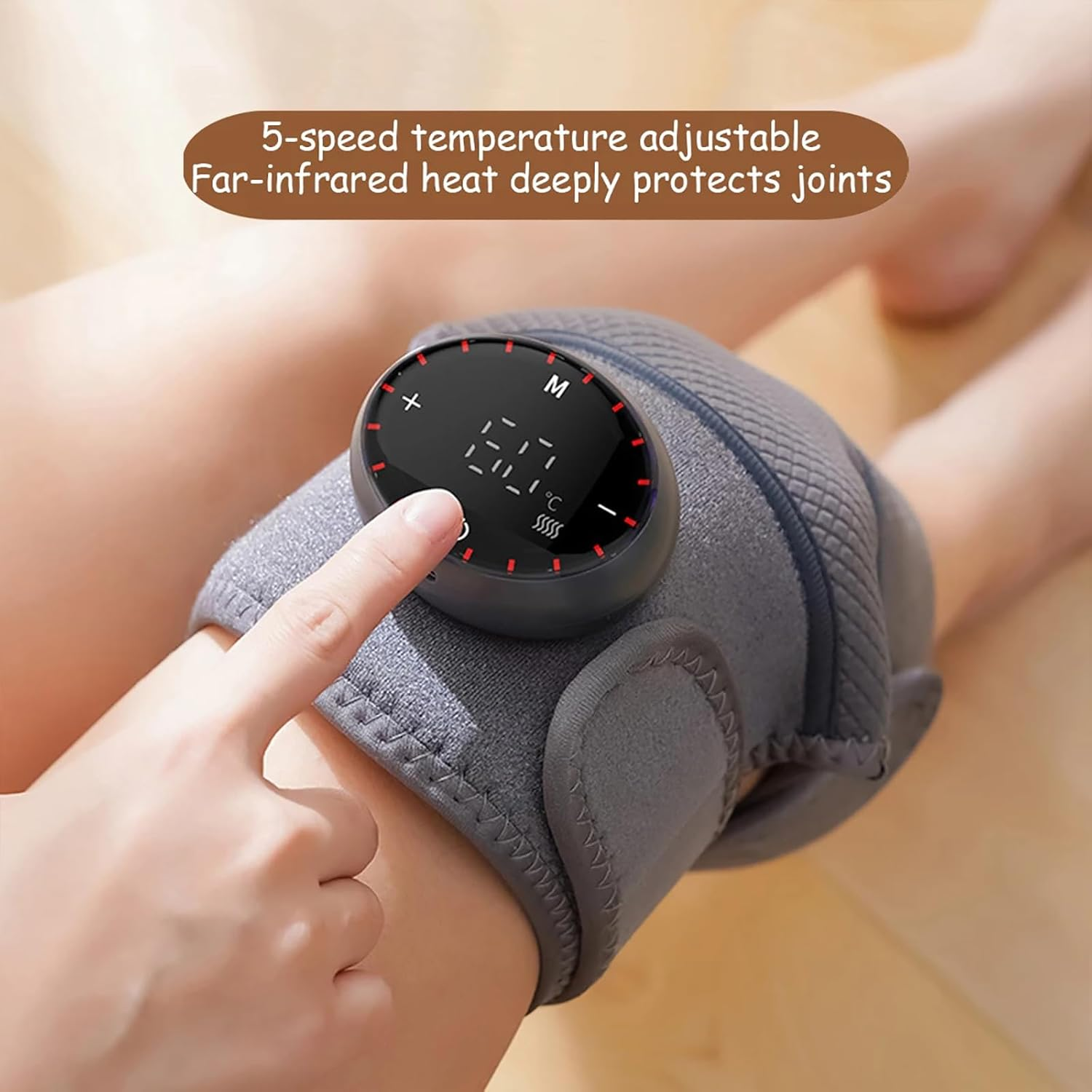 Die Hand einer Person stellt eine graue Knieorthese mit einer Digitalanzeige zur Temperatureinstellung ein.
