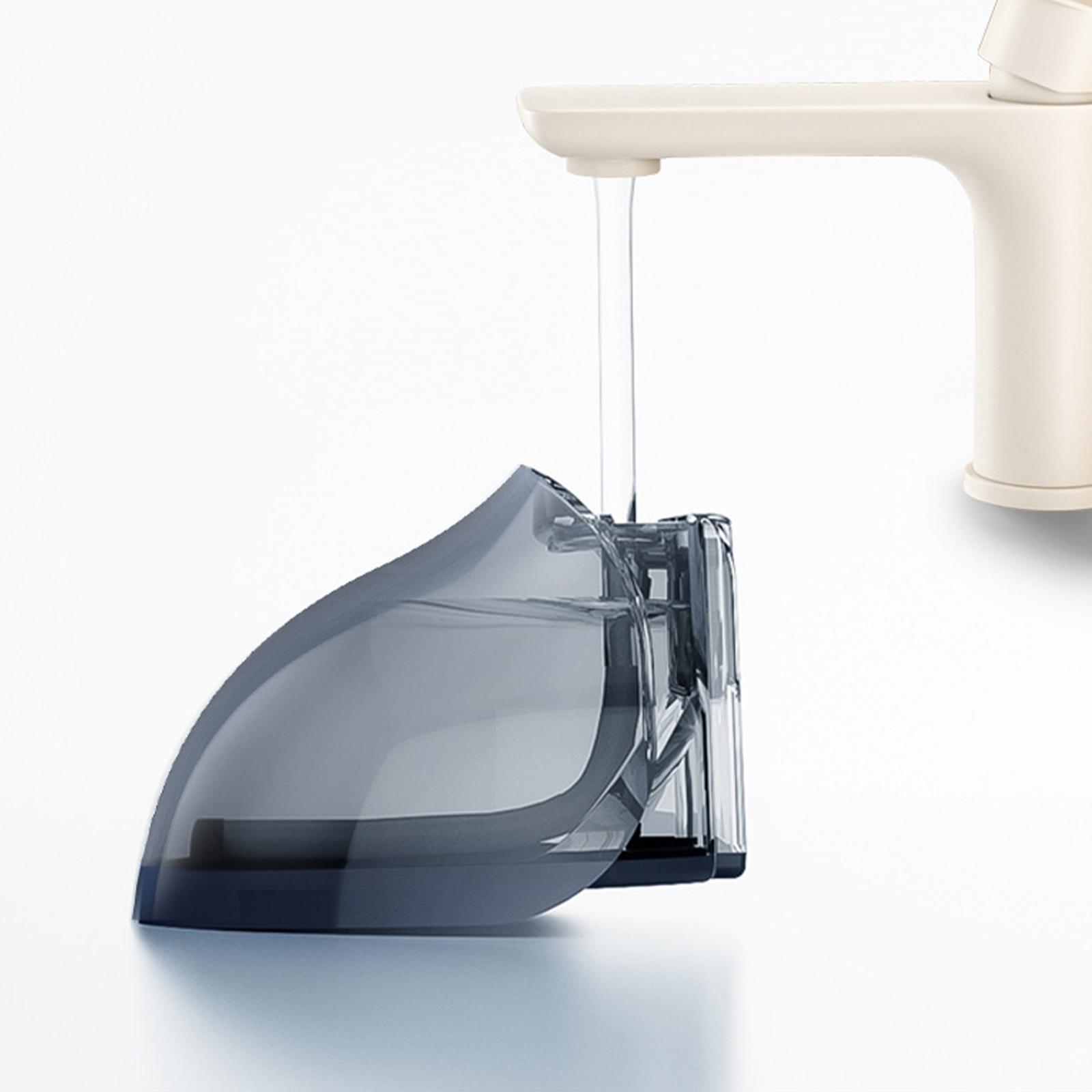 Wasser fließt aus einem cremefarbenen Wasserhahn in einen grauen, gebogenen Behälter.