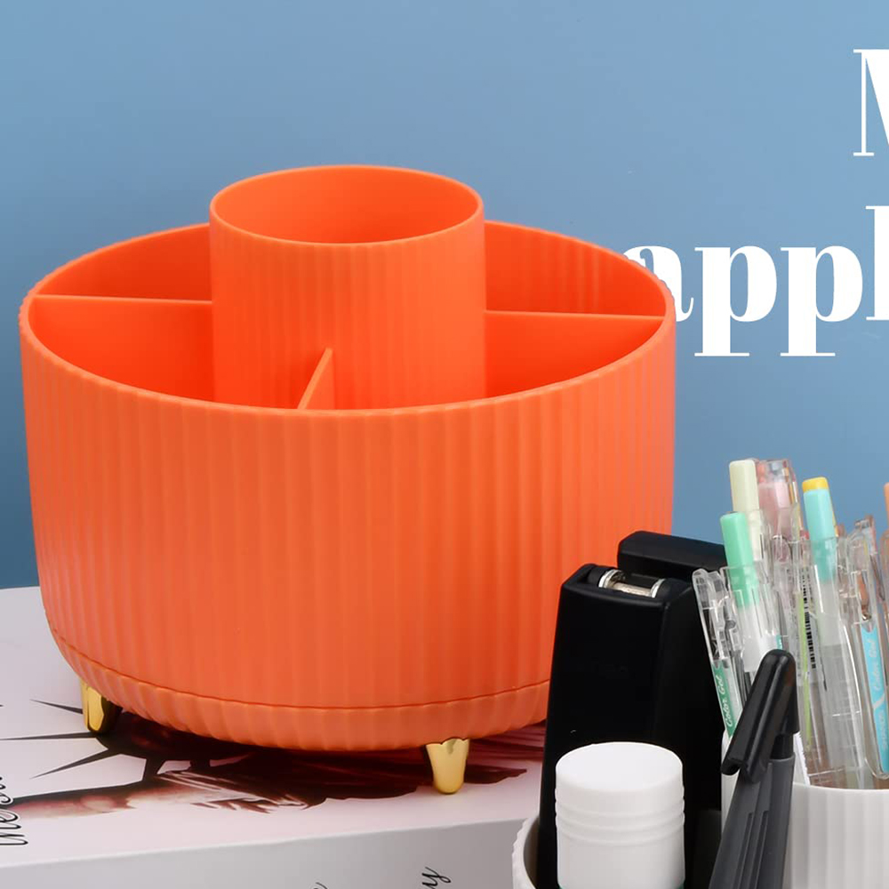 Ein orangefarbener Schreibtischorganizer mit goldenen Füßen und Fächern, mit Büromaterialien drumherum.