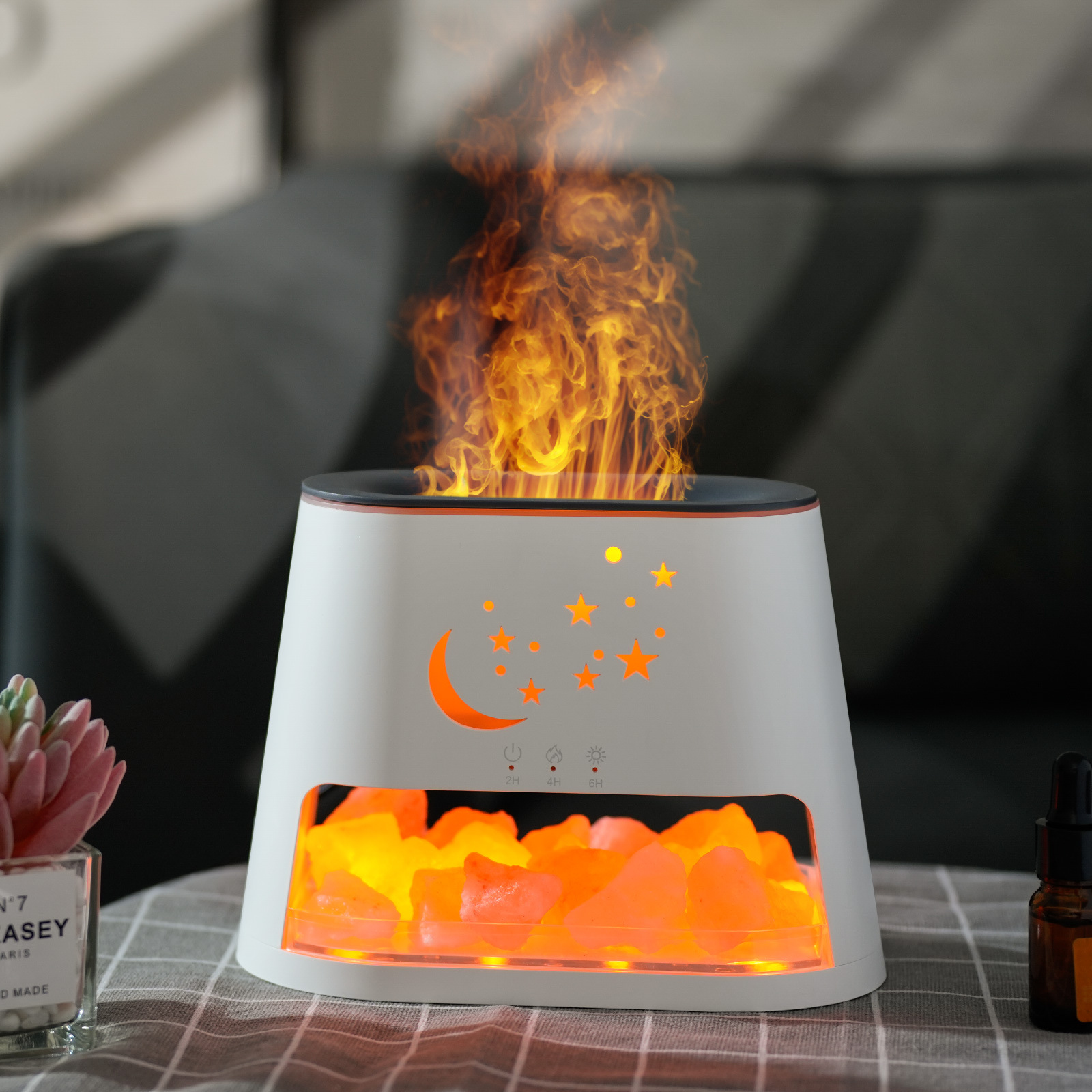 Ein weiß-oranger, flammenförmiger Luftbefeuchter mit dekorativen Lichtern und dunklem Hintergrund.