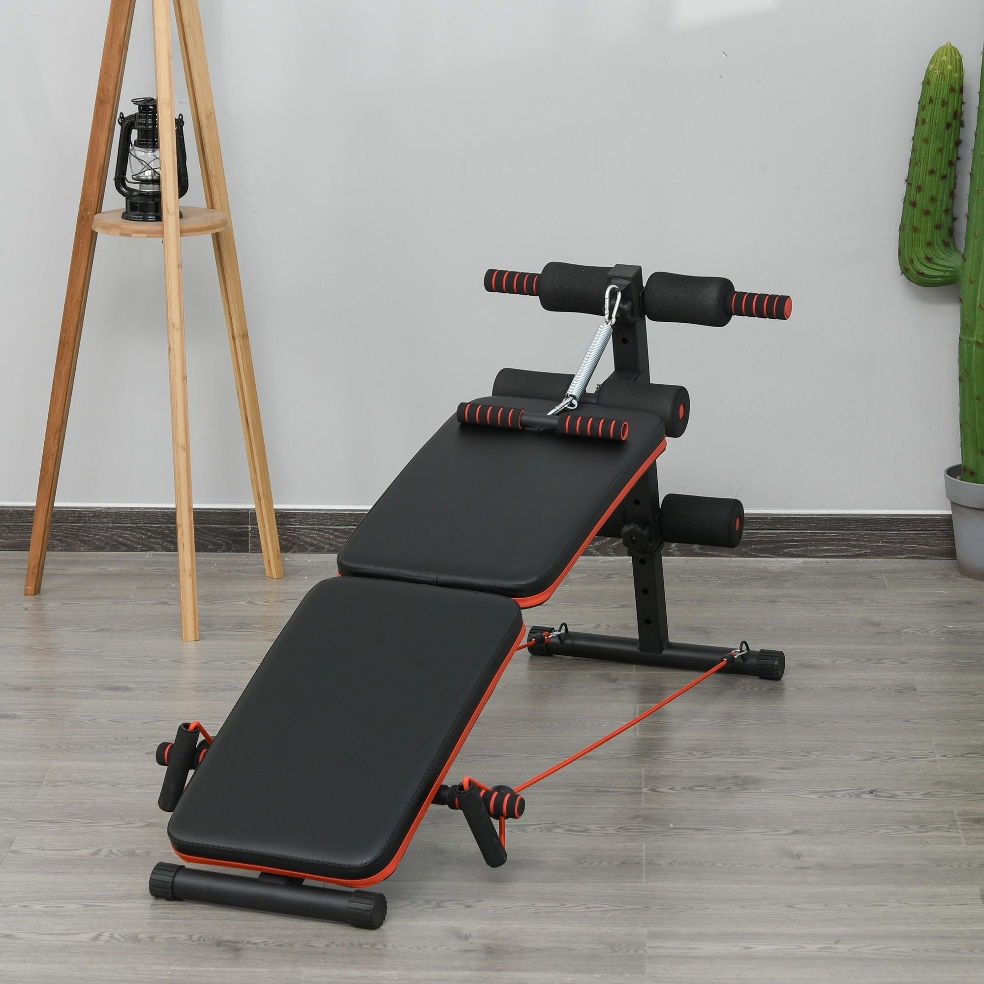 Eine schwarz-orange verstellbare Trainingsbank mit Zubehör, vor einem neutralen Hintergrund.