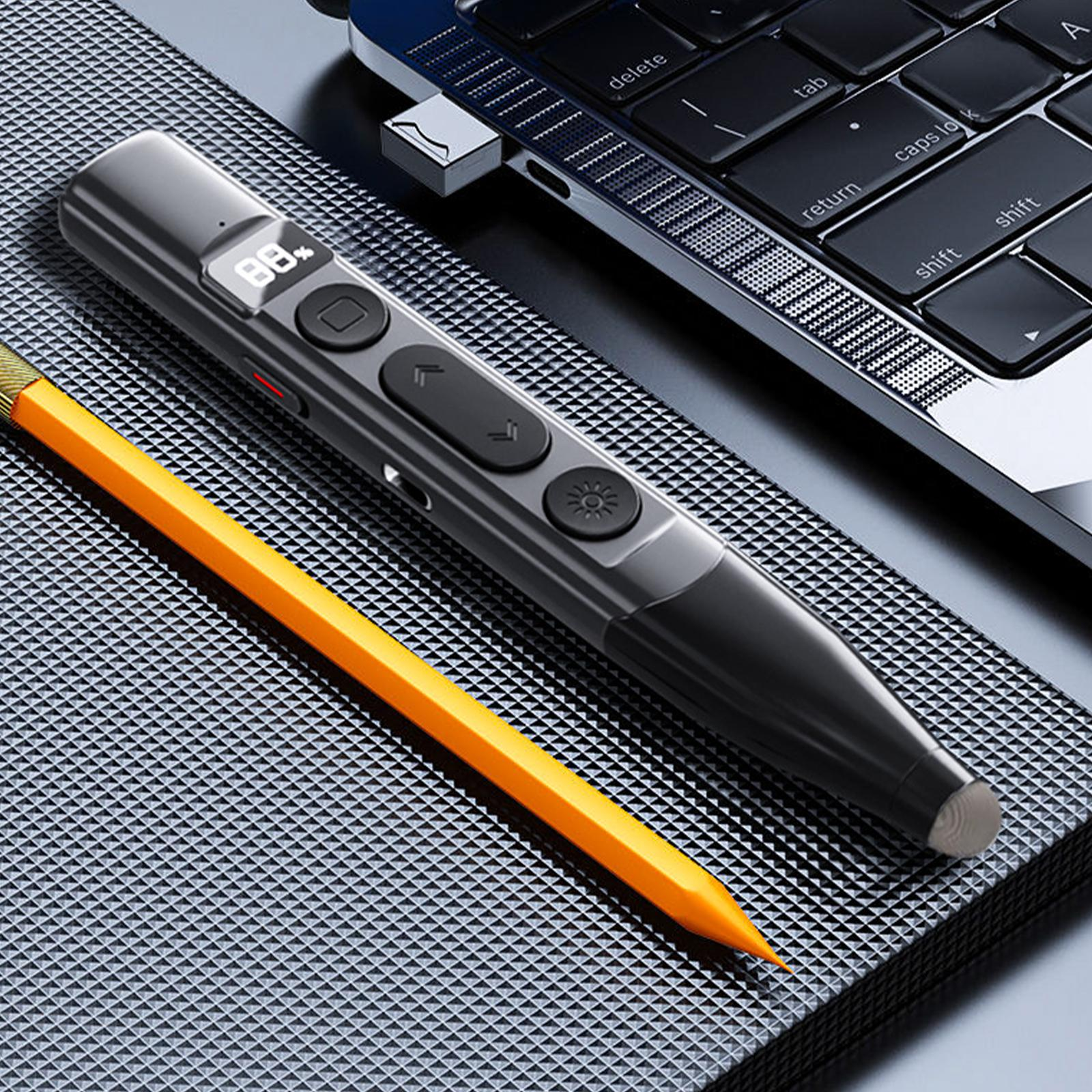 Grauer Präsentationspointer und gelber Bleistift liegen auf einer strukturierten Oberfläche neben einem Laptop.