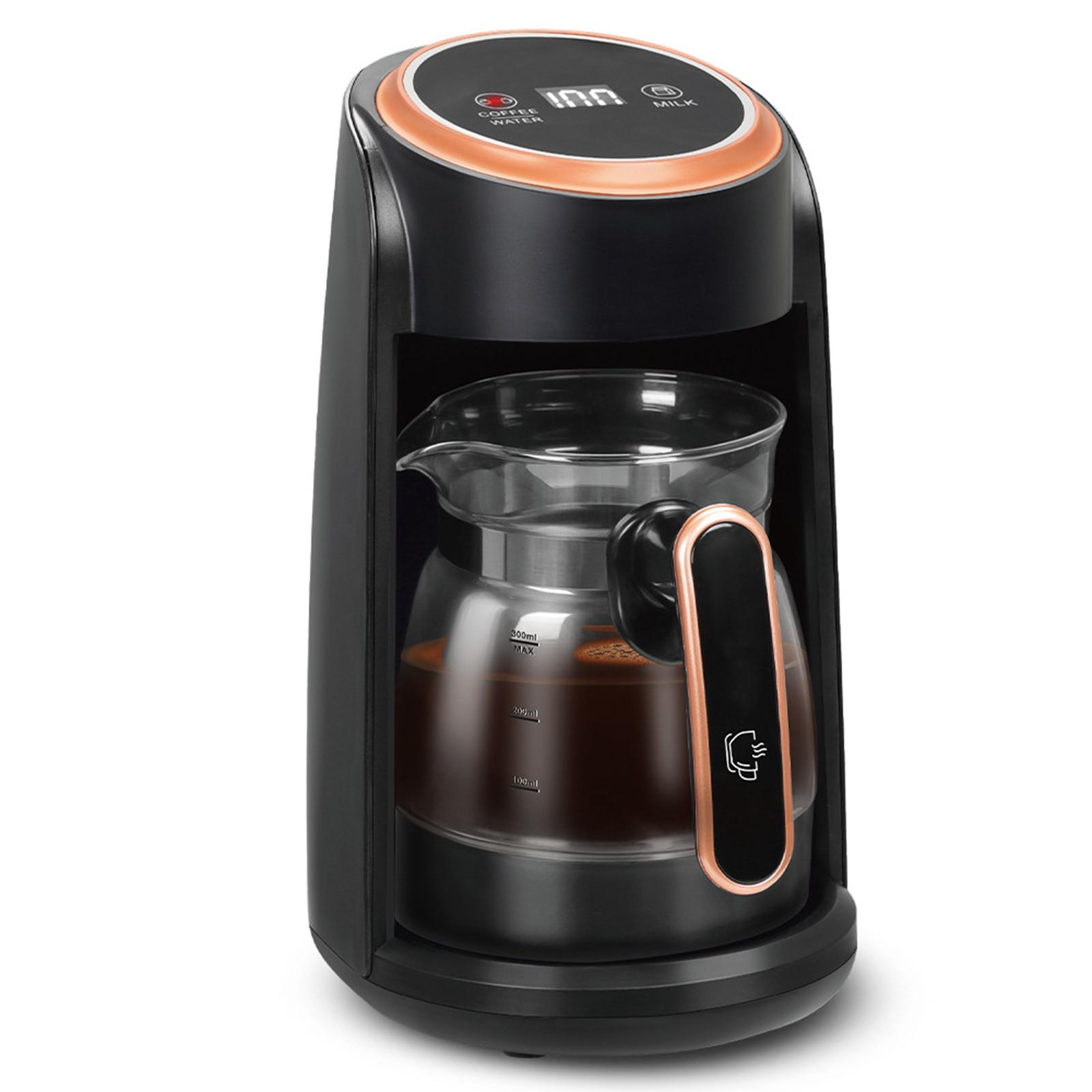 Eine schwarze Kaffeemaschine mit einer Glaskaraffe, die mit Kaffee gefüllt ist, auf einer schwarzen Oberfläche steht.
