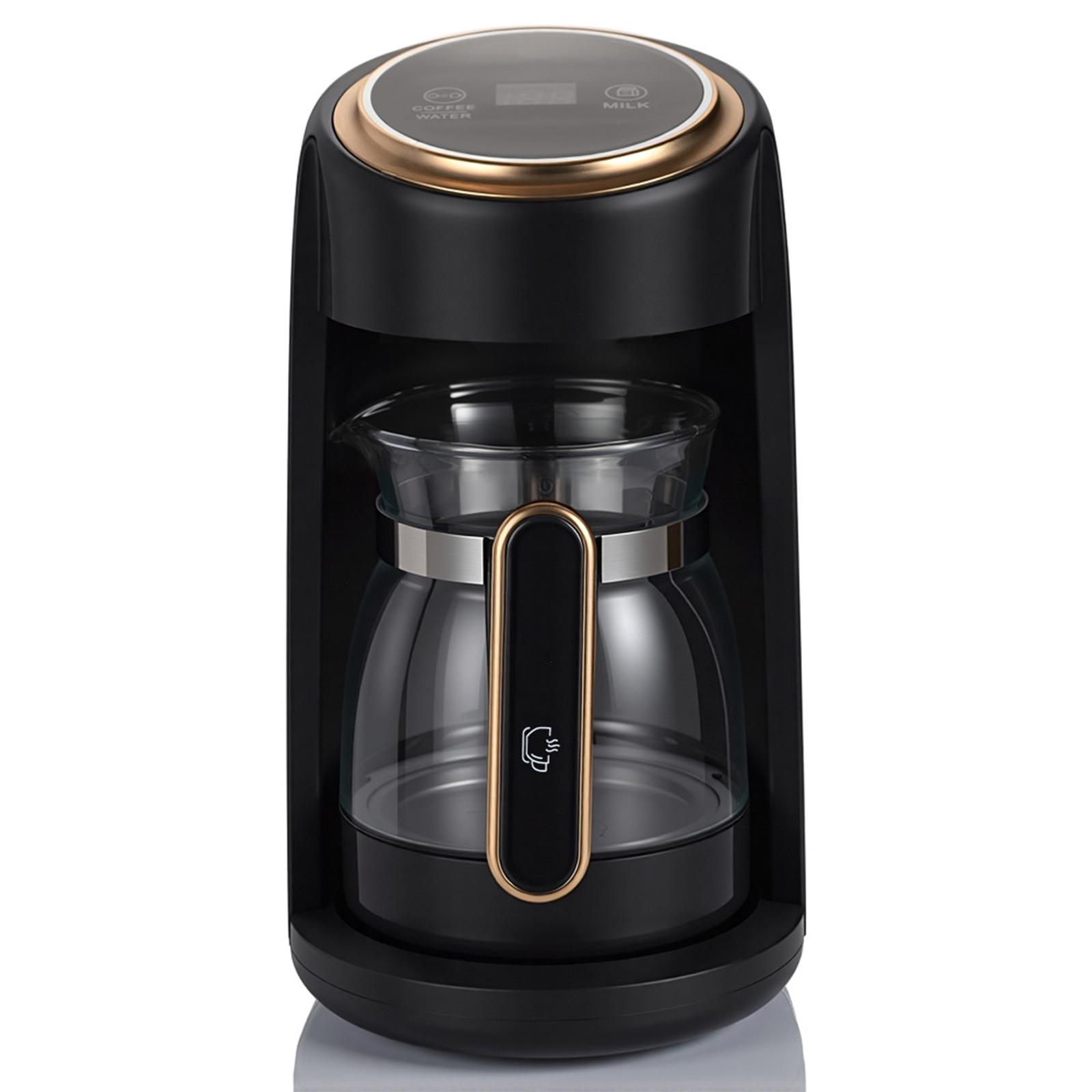 Schwarze Kaffeemaschine mit Glaskaraffe und goldenen Akzenten. Sie steht auf einer weißen Oberfläche mit schwarzem Rand.