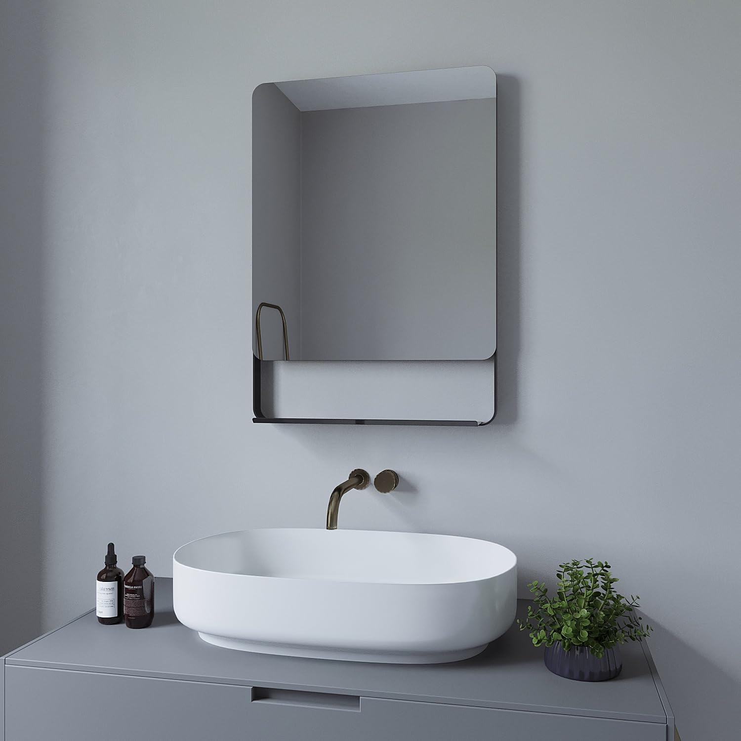 Badezimmer mit Spiegel, Waschbecken und Flaschen. Die Wand ist grau.