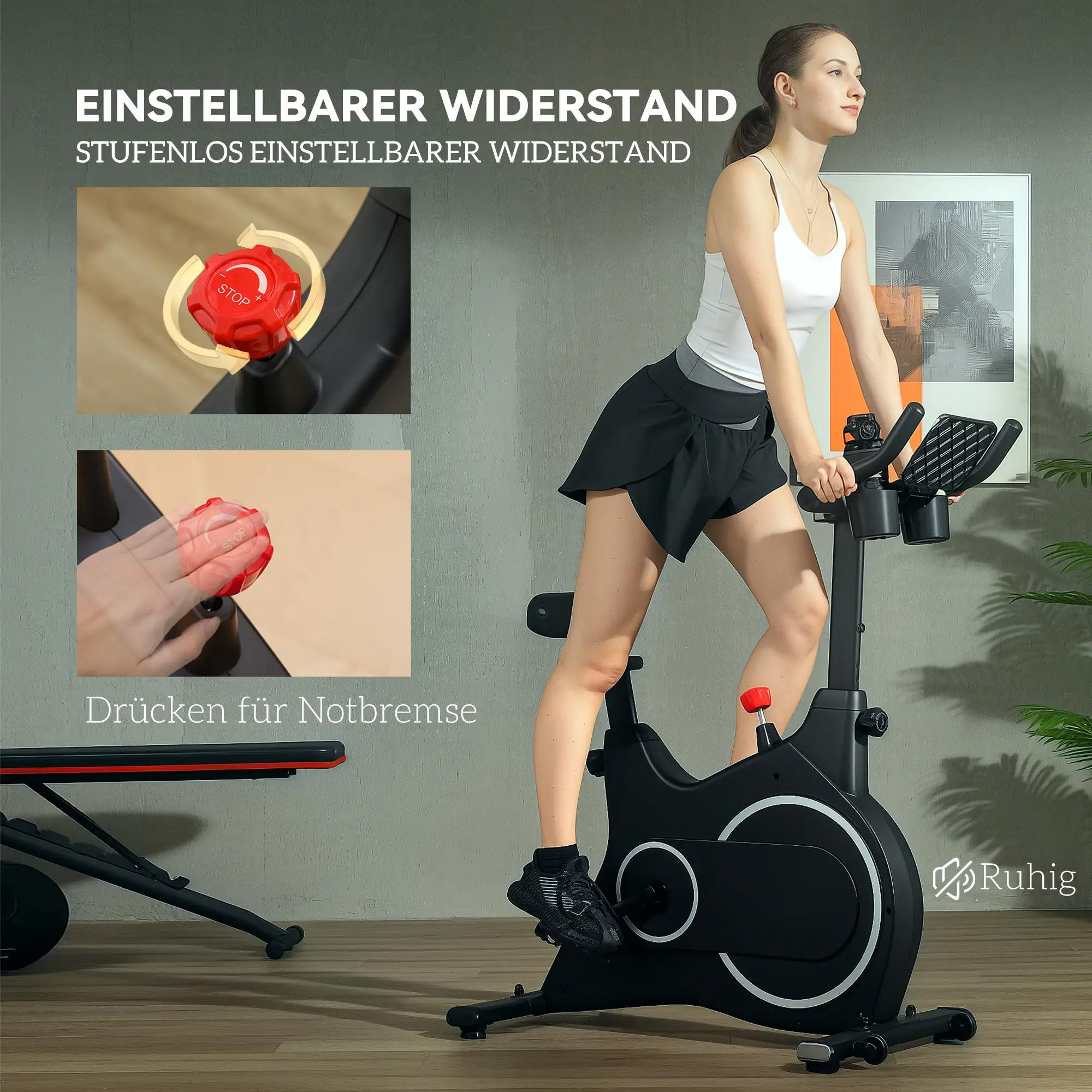 Frau auf einem schwarzen Heimtrainer. Anzeigen der Fahrradsteuerungen und roter Stopp-Knopf. Das Fahrrad steht vor hellem Hintergrund.
