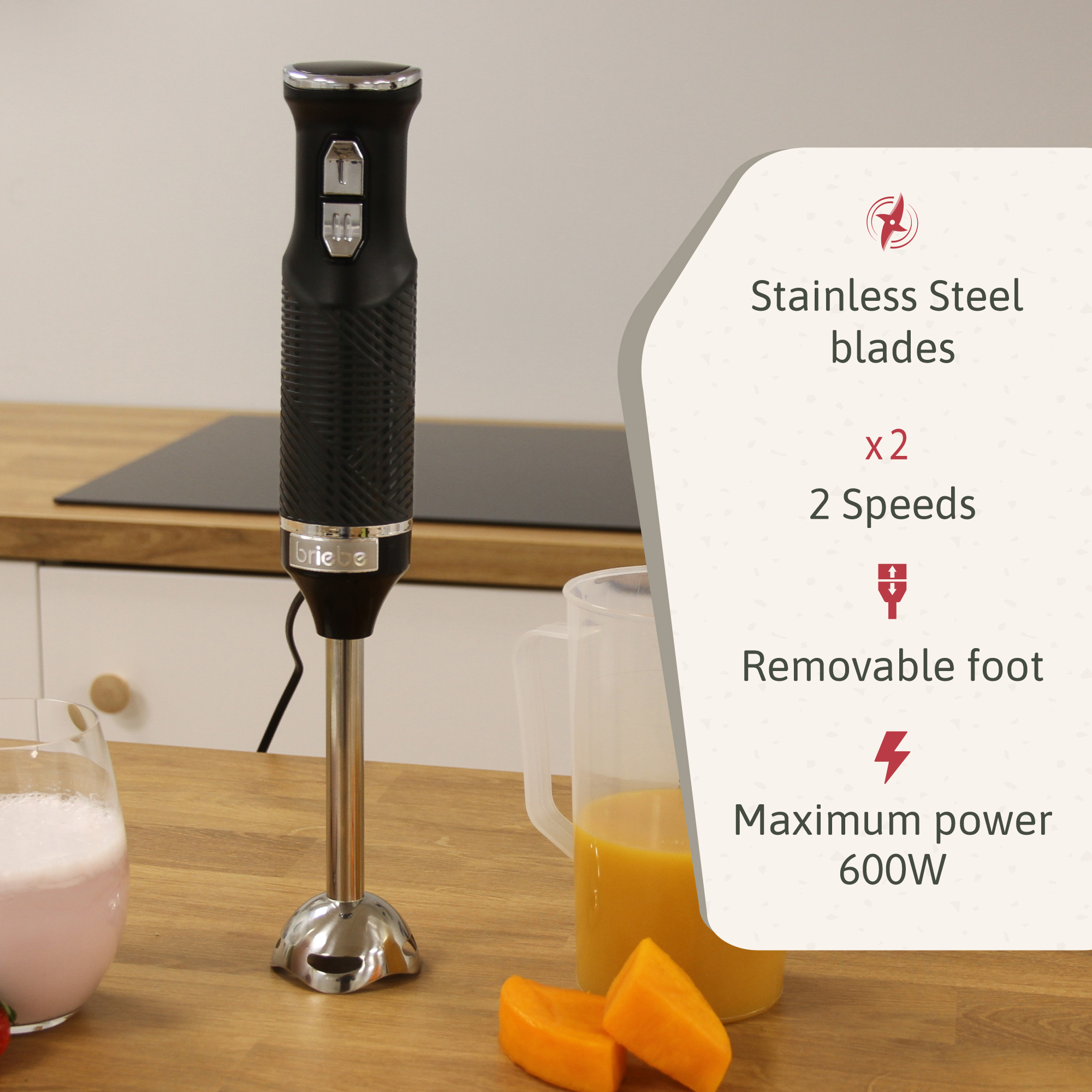 Schwarzer Stabmixer mit Produktdetails auf einer Holzoberfläche mit Obst und einem Getränk.