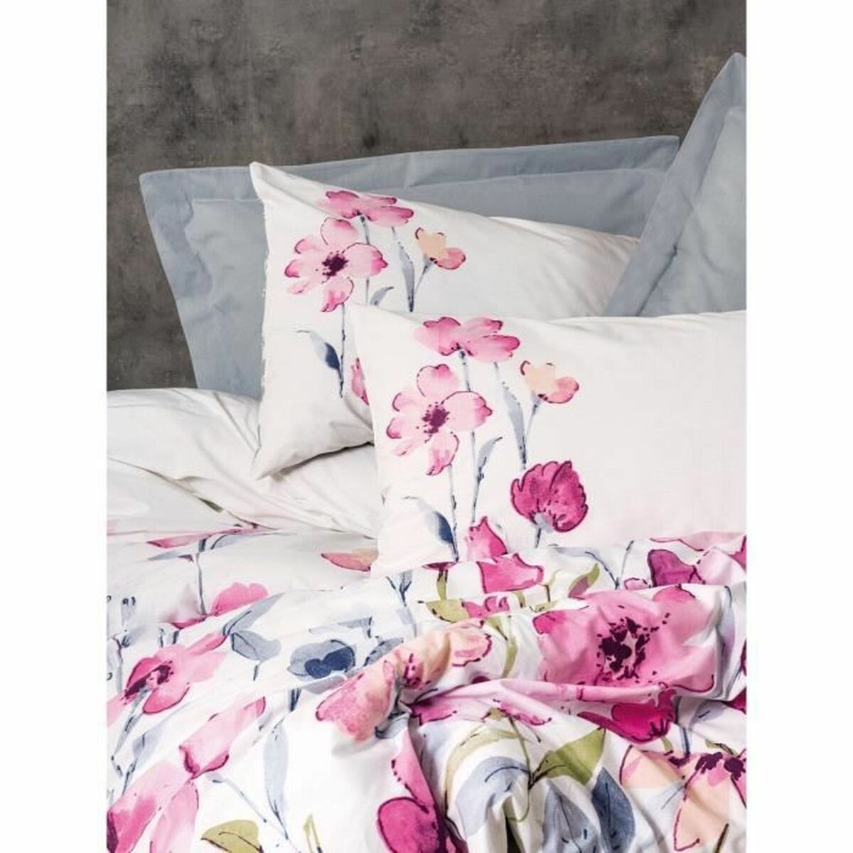 Weiße Bettwäsche mit rosa Blumenmuster. Zwei Kissen mit Blumen.