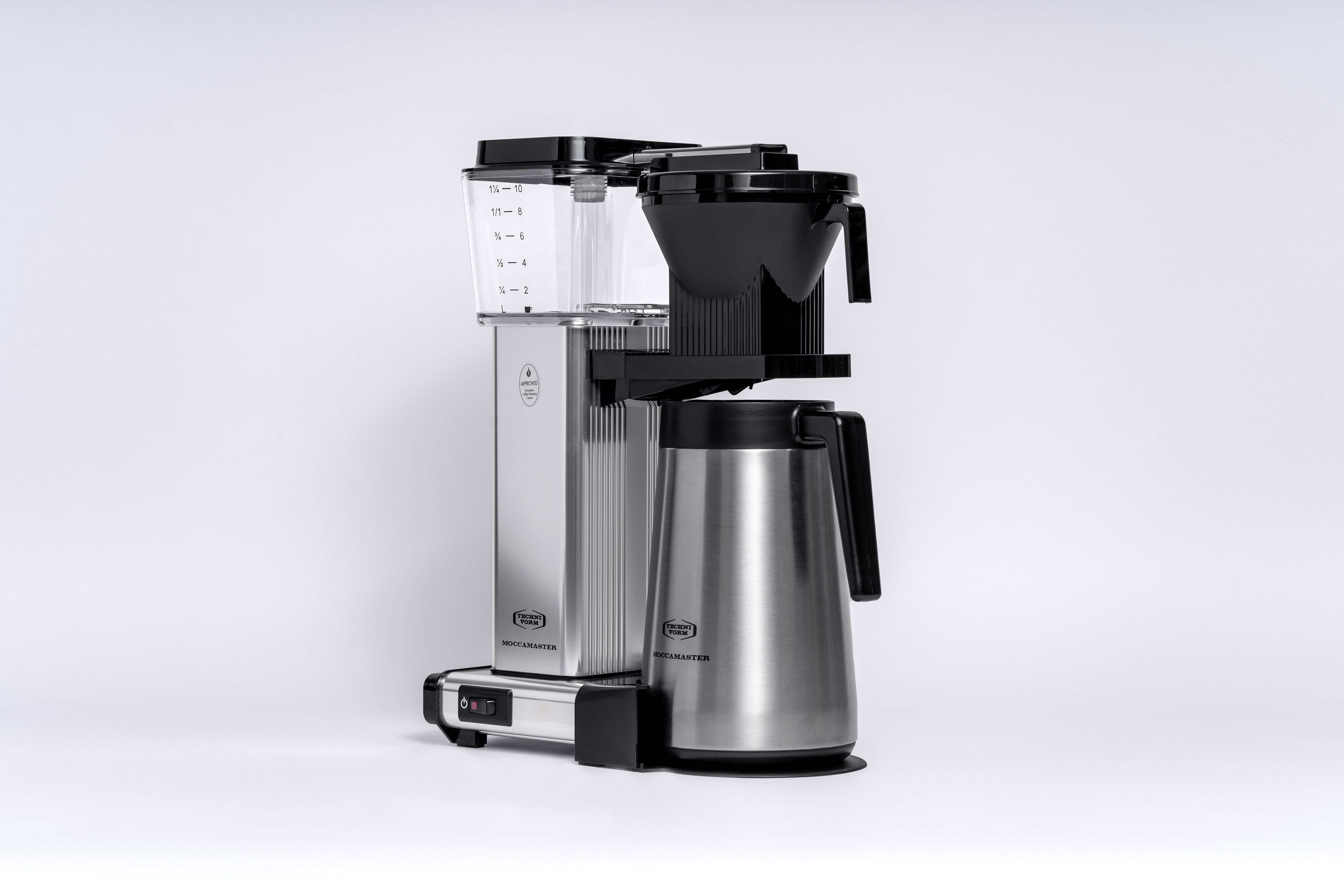 Une cafetière argentée et noire avec une carafe en verre et un porte-filtre noir.