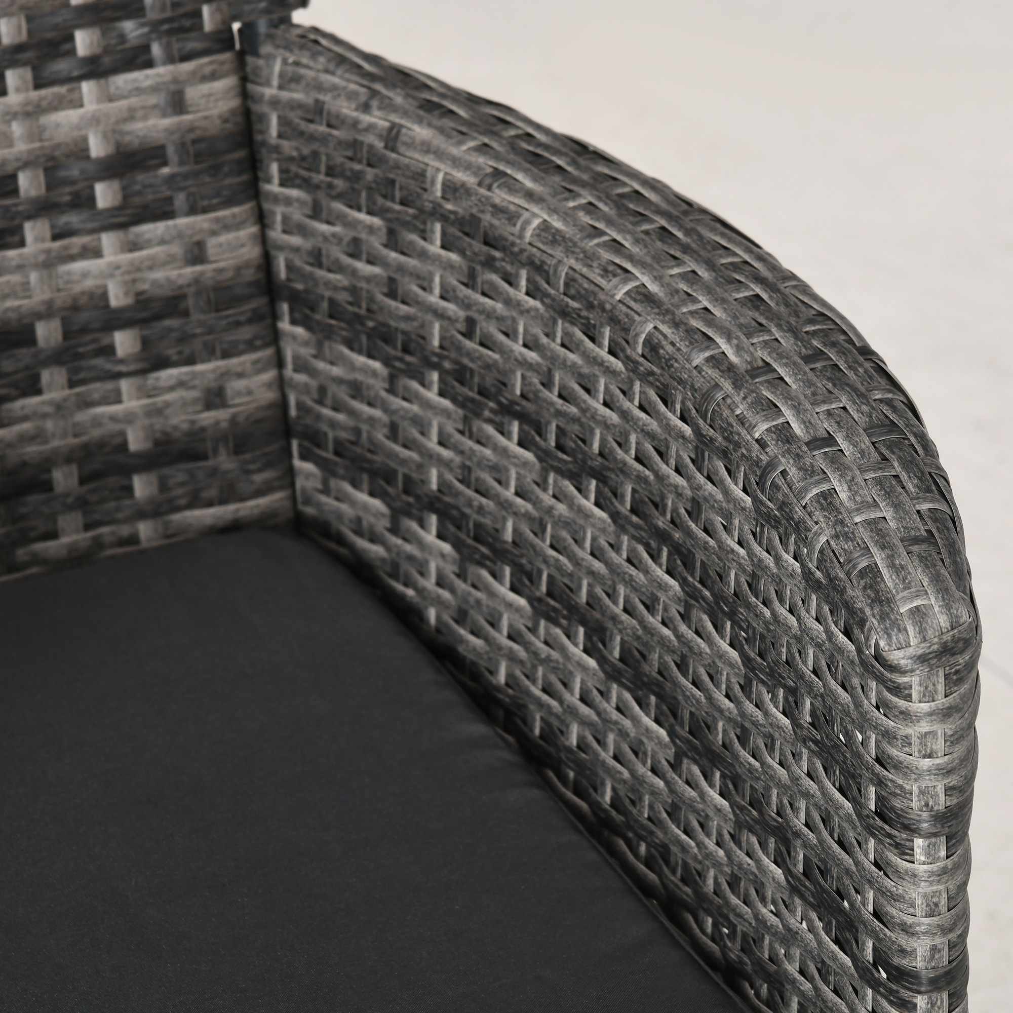 Nahaufnahme eines grauen Rattan-Stuhls. Zeigt die Textur des gewebten Materials.