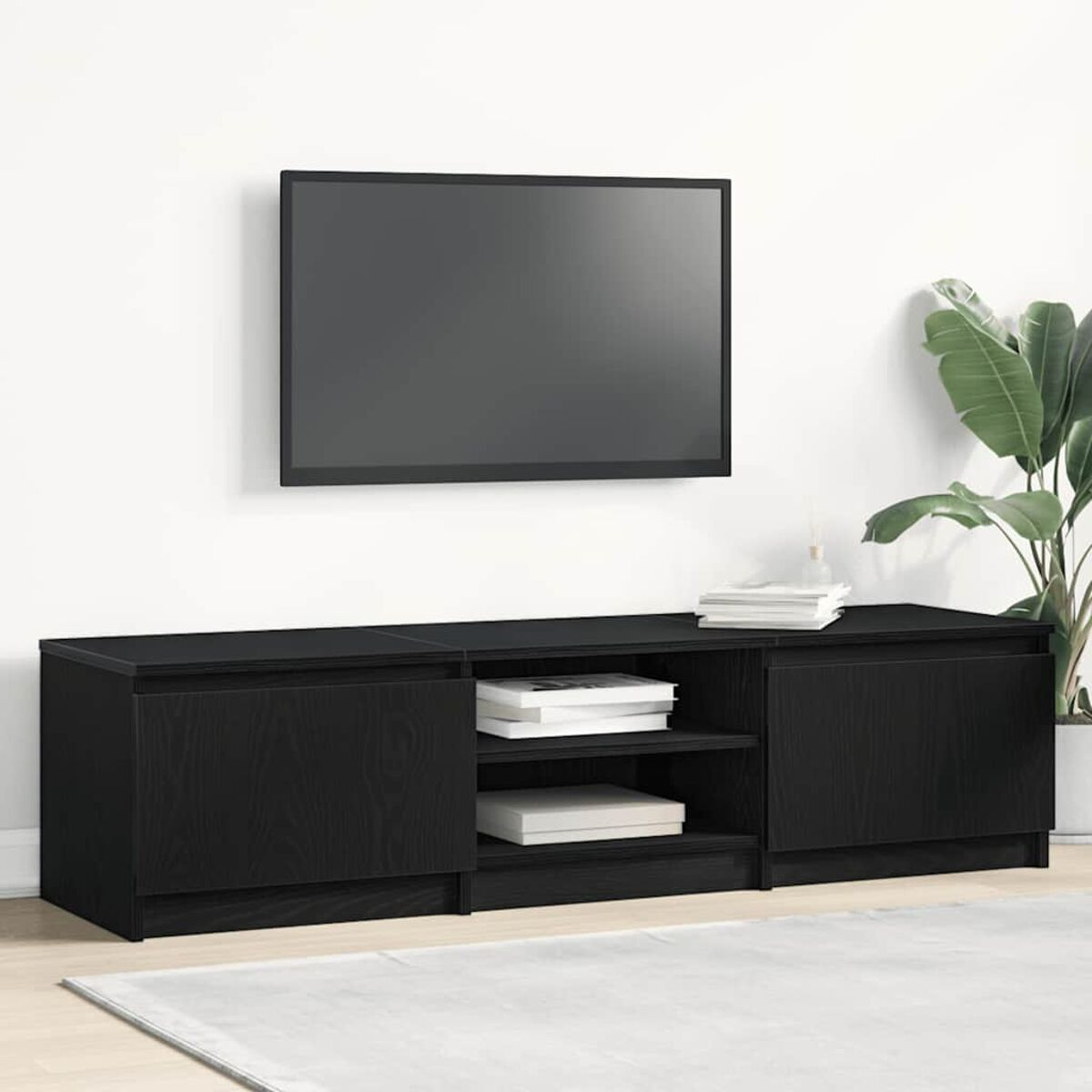 Ein schwarzer TV-Ständer mit Fernseher und Büchern.