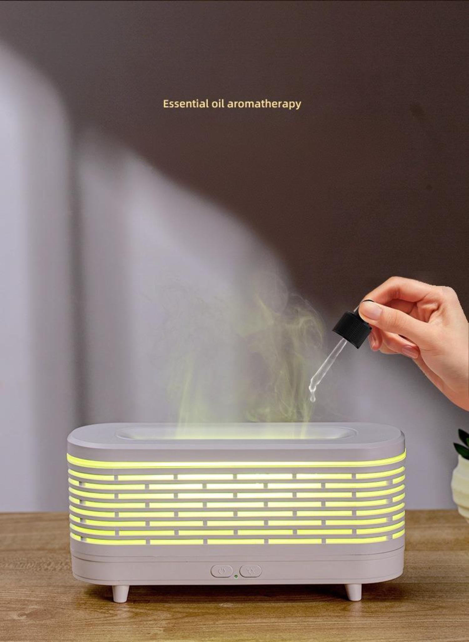 Ein Aromadiffusor mit Dampf und eine Hand, die Öltropfen platziert.