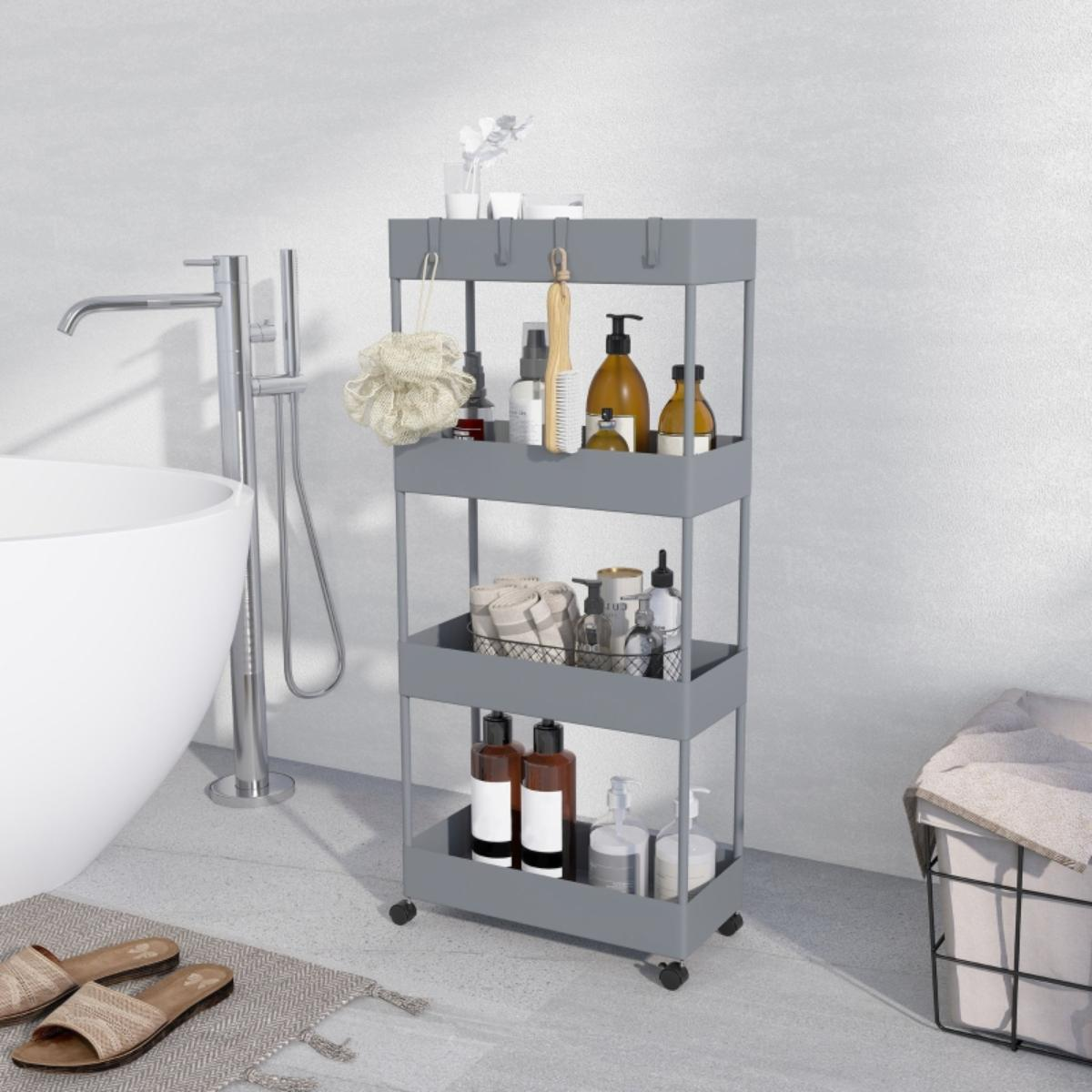 Ein grauer Rollwagen in einem Badezimmer, mit Gegenständen wie Seife, Lotionen und Handtüchern. Eine Badewanne ist sichtbar.