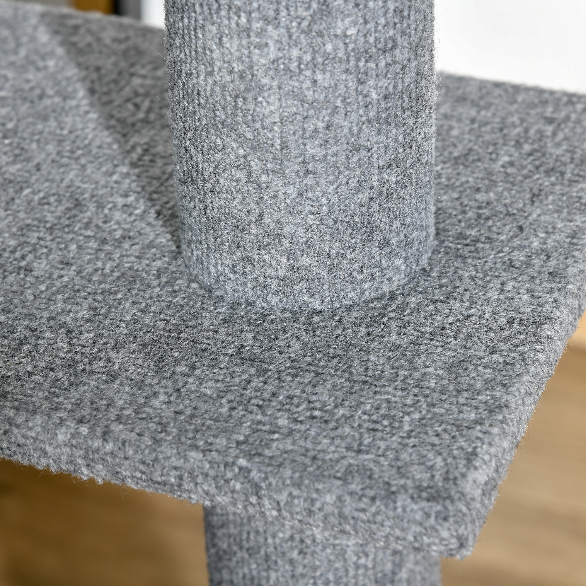 Nahaufnahme einer Katzenbaumplattform mit grauem Teppichmuster.