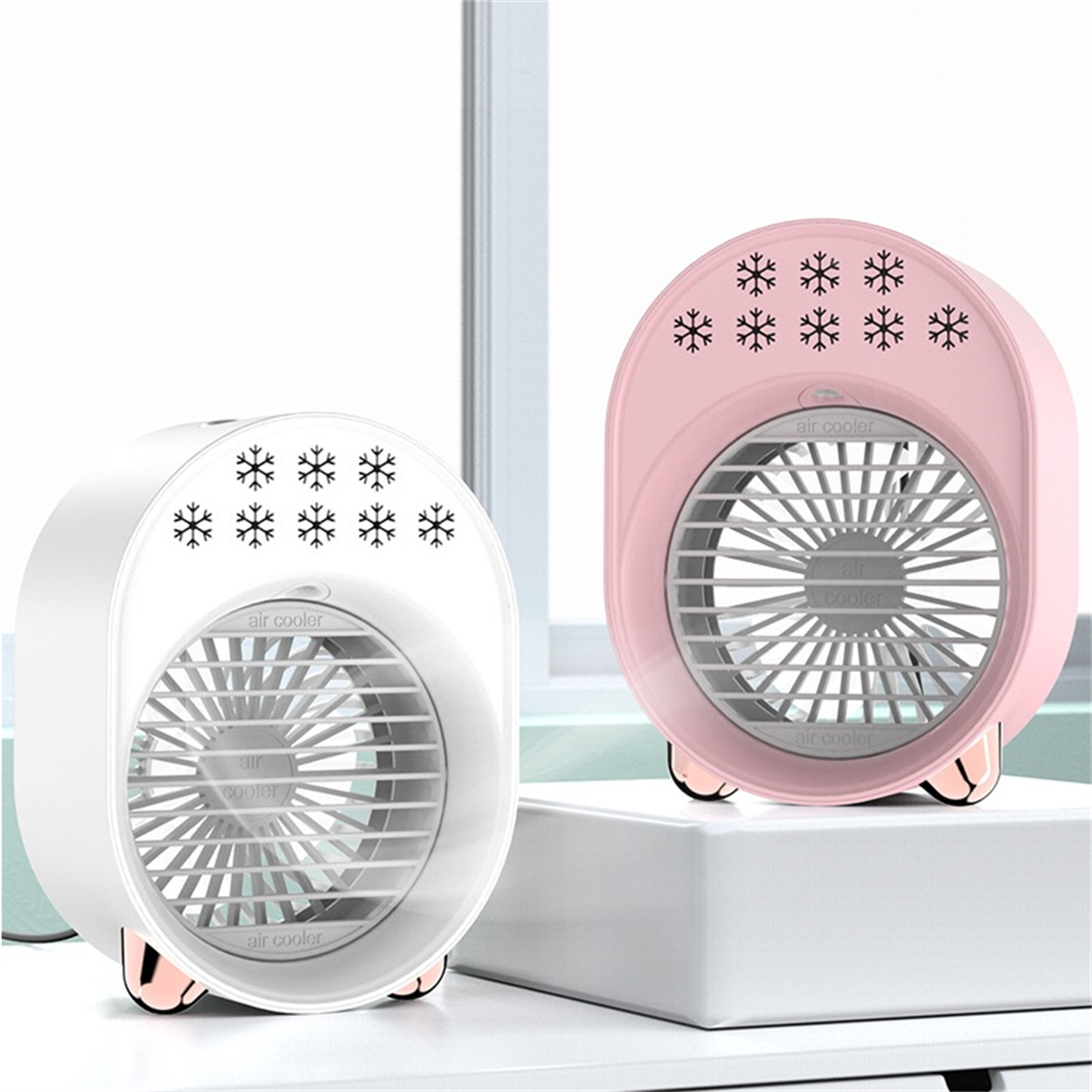 Zwei Mini-Luftkühler, weiß und rosa. Schneeflocken-Designs auf der Vorderseite. Weißer Hintergrund.