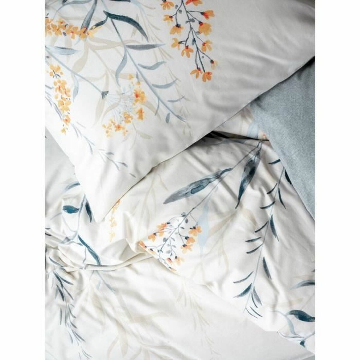 Bettwäsche mit weißem Blumendruck mit orangefarbenen und blauen Details.