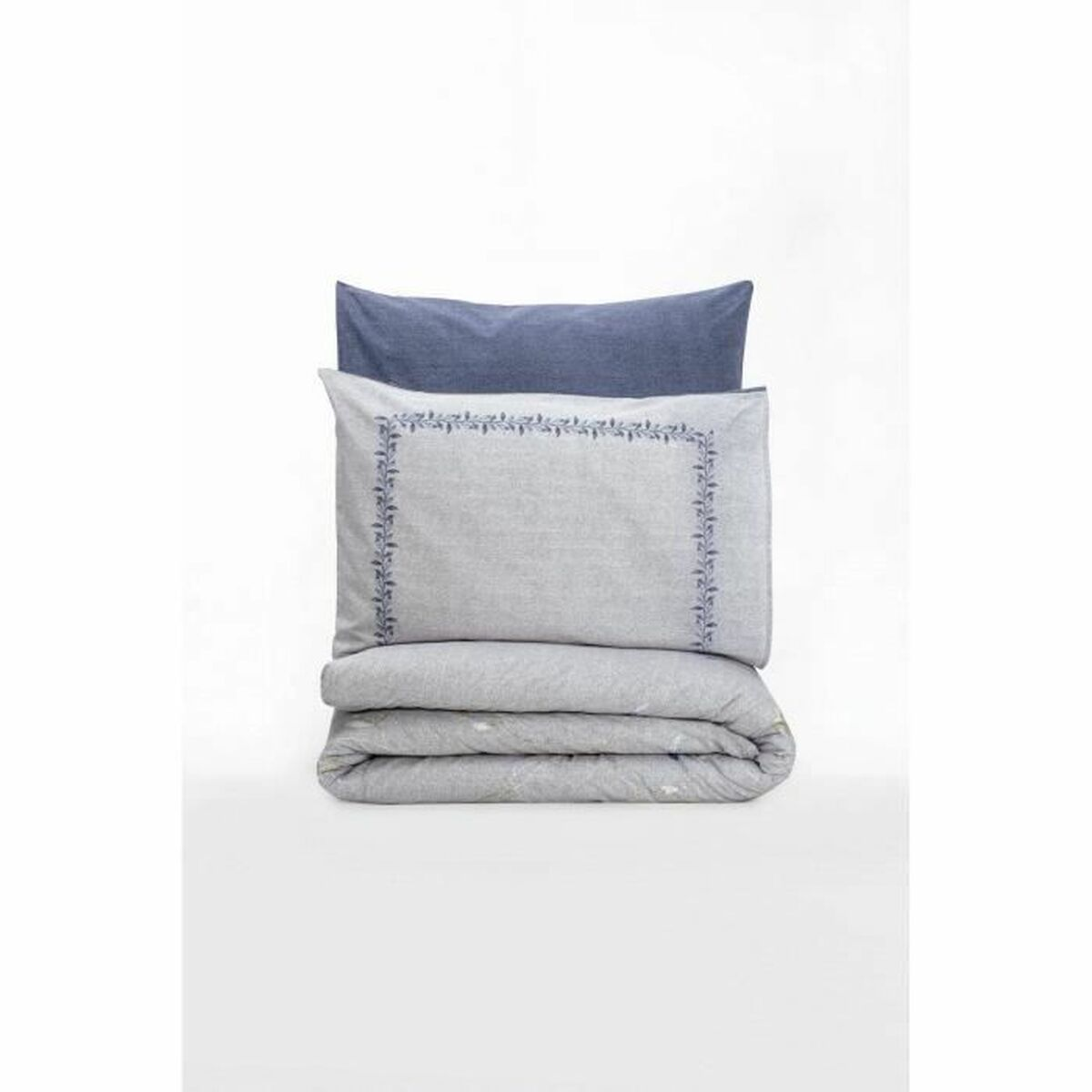 Ein gefaltetes Bettwäsche-Set mit einem blauen Kissenbezug und einer grauen Decke auf weißem Hintergrund.