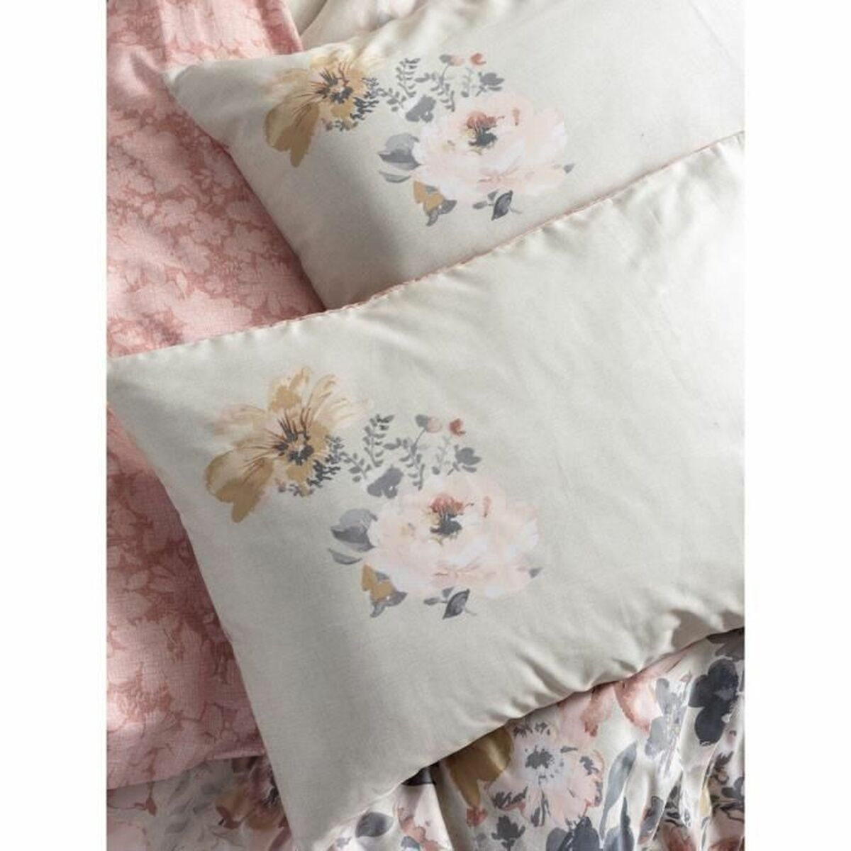 Weiße Kissen mit rosa Blumendesign. Der Hintergrund ist weiß.